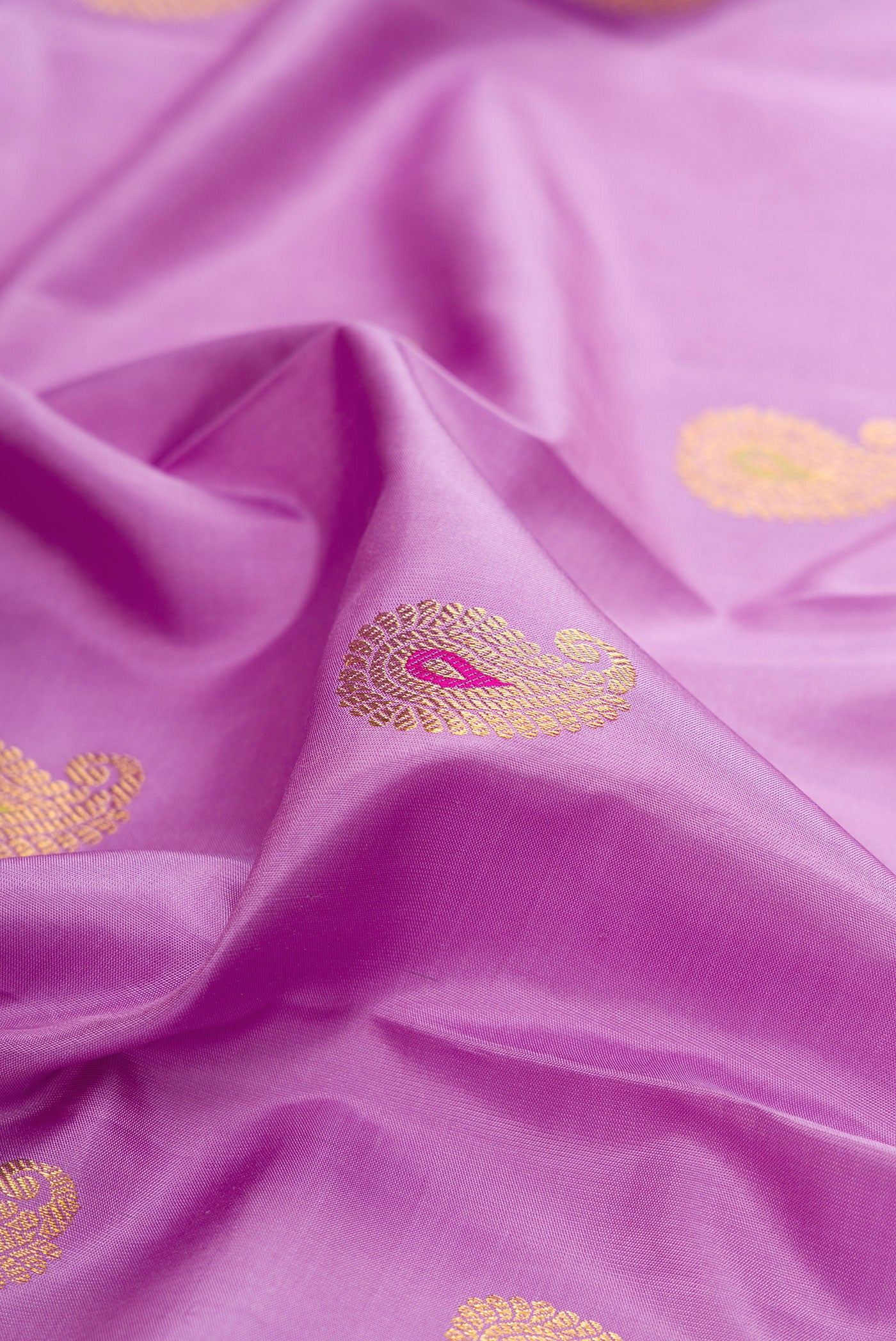 Close up of Pure Silk Pure Zari Lavender Kanjivaram Saree with Zari And Thread Butta on the body and Fancy Border.  displaying folds
