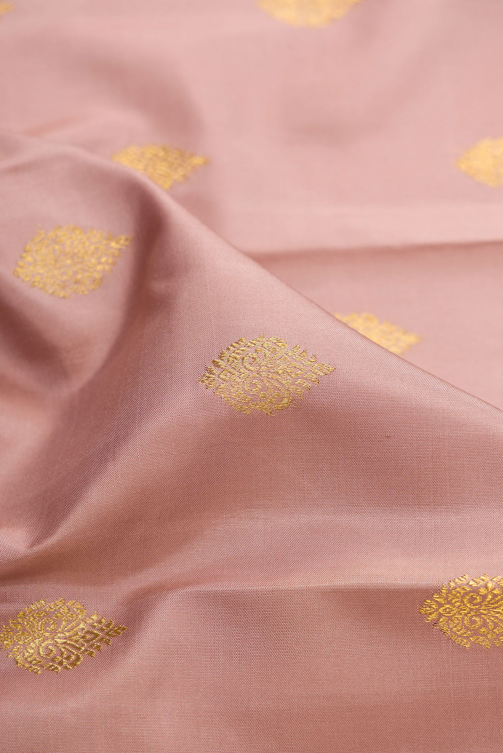 Close up of Pure Silk Pure Zari Rose Gold Kanjivaram Saree with Zari Butta on the body and Fancy Border.  displaying folds