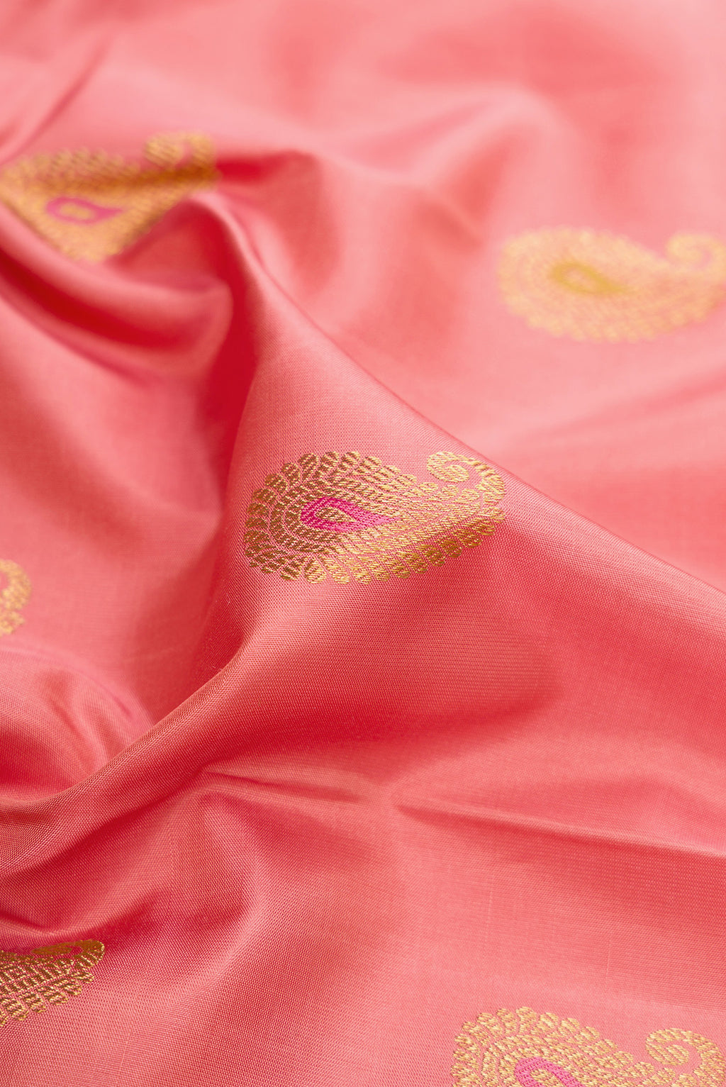 Close up of Pure Silk Pure Zari Coral Kanjivaram Saree with Zari And Thread Butta on the body and Fancy Border.  displaying folds