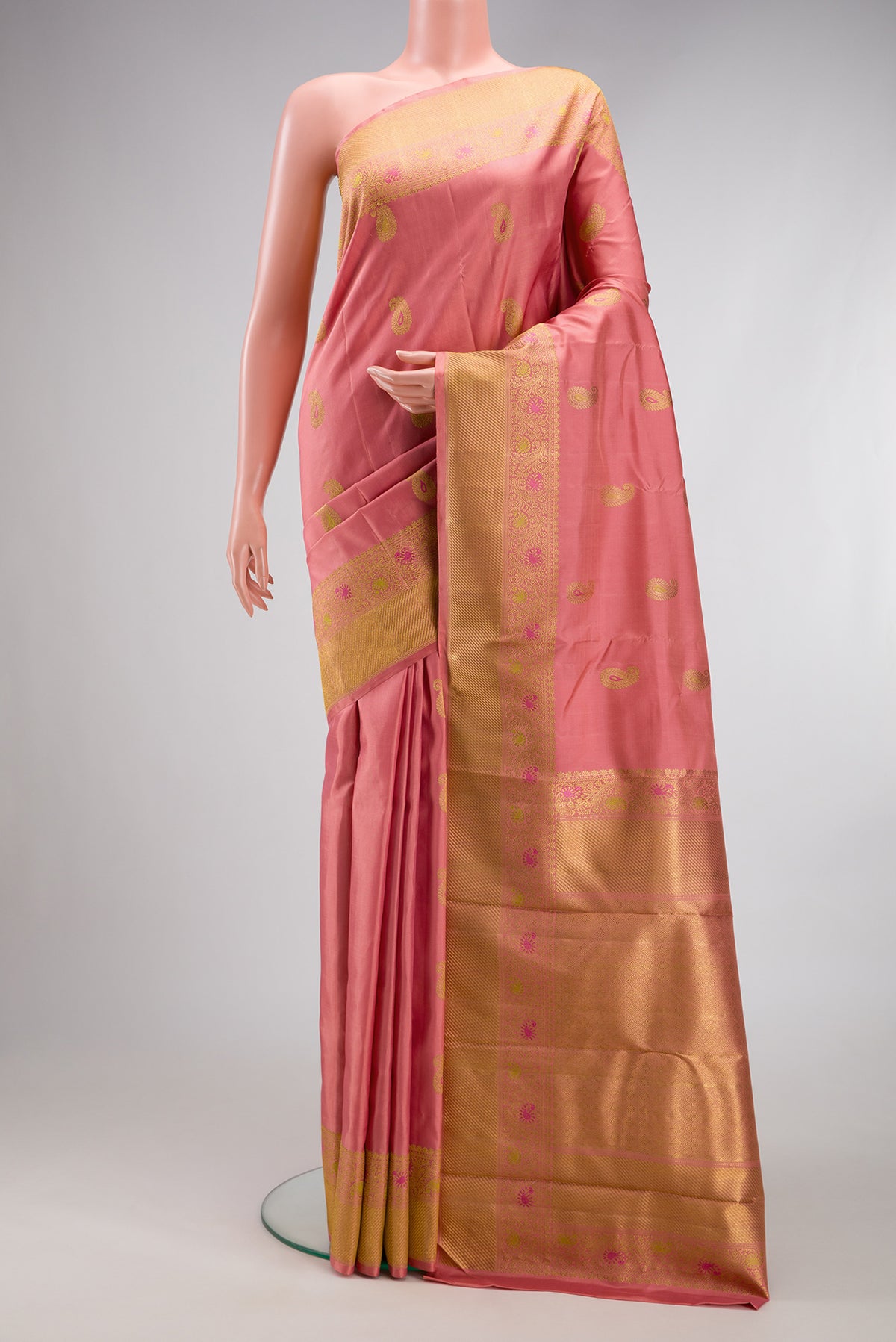 Pure Silk Pure Zari Coral Kanjivaram Saree with Zari And Thread Butta on the body and Fancy Border.  displayed on a mannequin