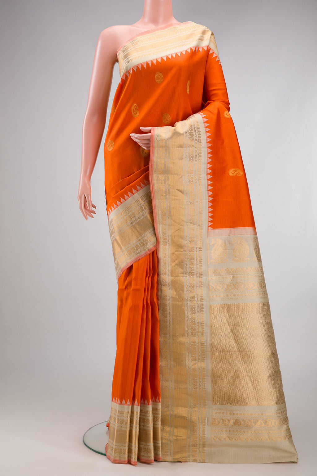 Orange Gadwal Silk Saree with Zari Butta on the body and Zari Border.  displayed on a mannequin