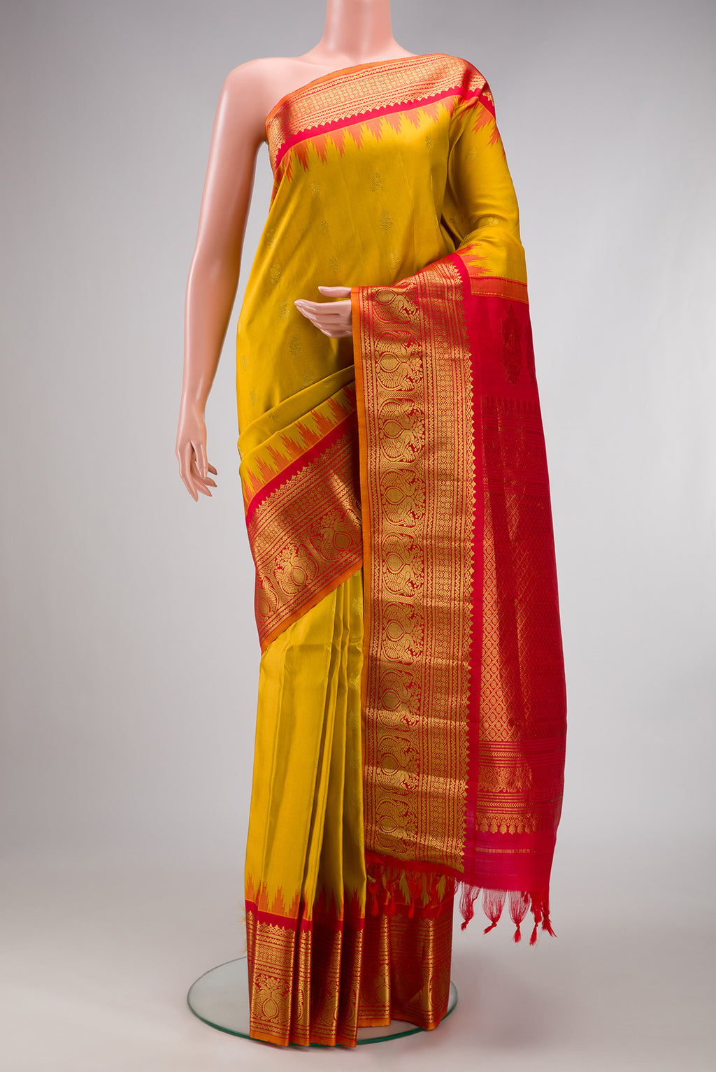 Mustard Gadwal Silk Saree with Zari Butta on the body and Zari Border.  displayed on a mannequin