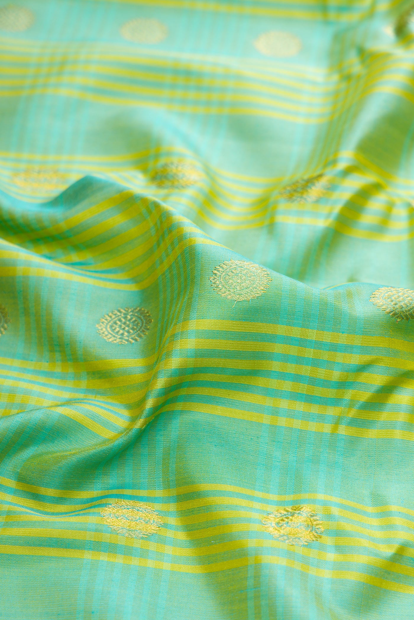 Close up of Sea Green Gadwal Silk Saree with Checked design on the body and Zari Border.  displaying folds
