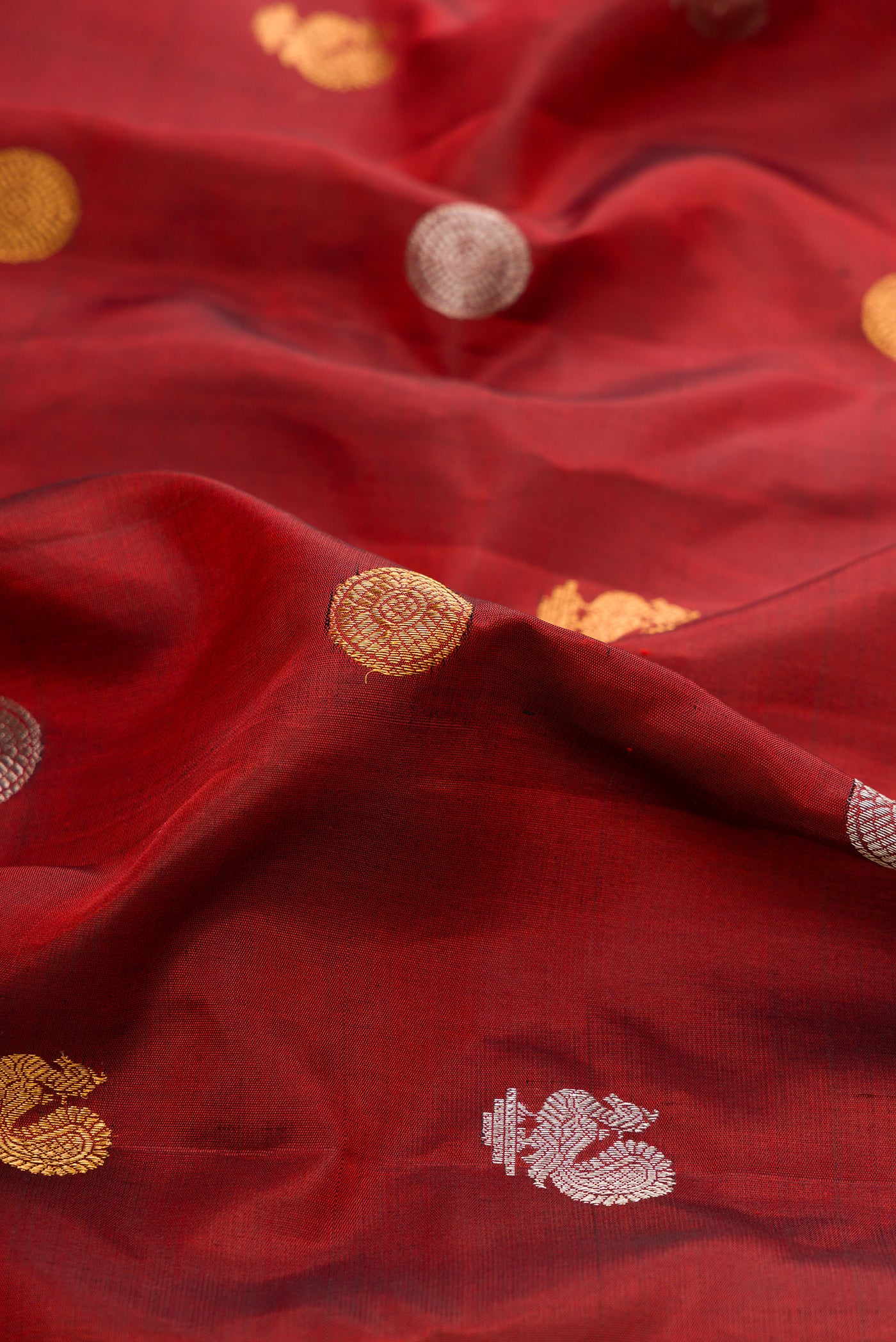 Close up of Maroon Gadwal Silk Saree with Zari Butta on the body and Zari Border.  displaying folds