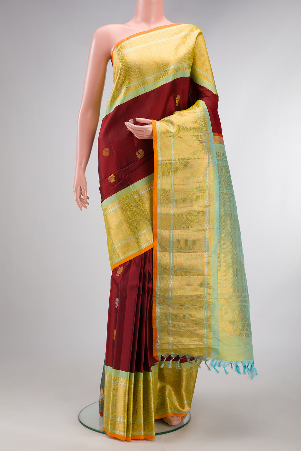 Maroon Gadwal Silk Saree with Zari Butta on the body and Zari Border.  displayed on a mannequin