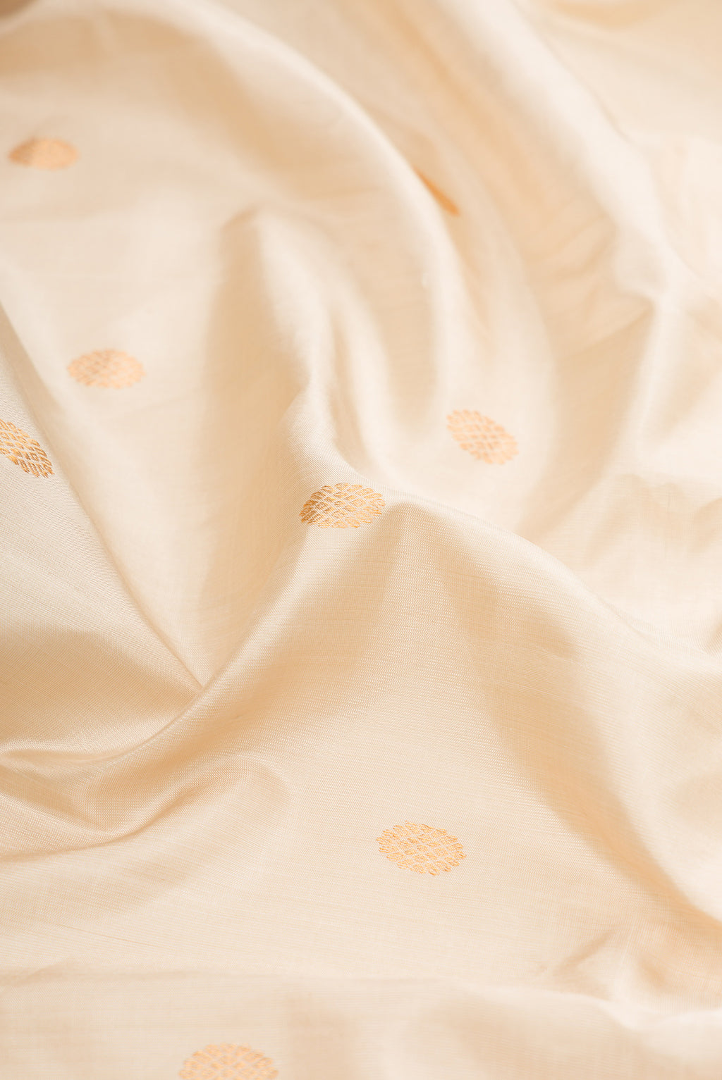 Close up of Cream Gadwal Silk Saree with Zari Butta on the body and Zari Border.  displaying folds