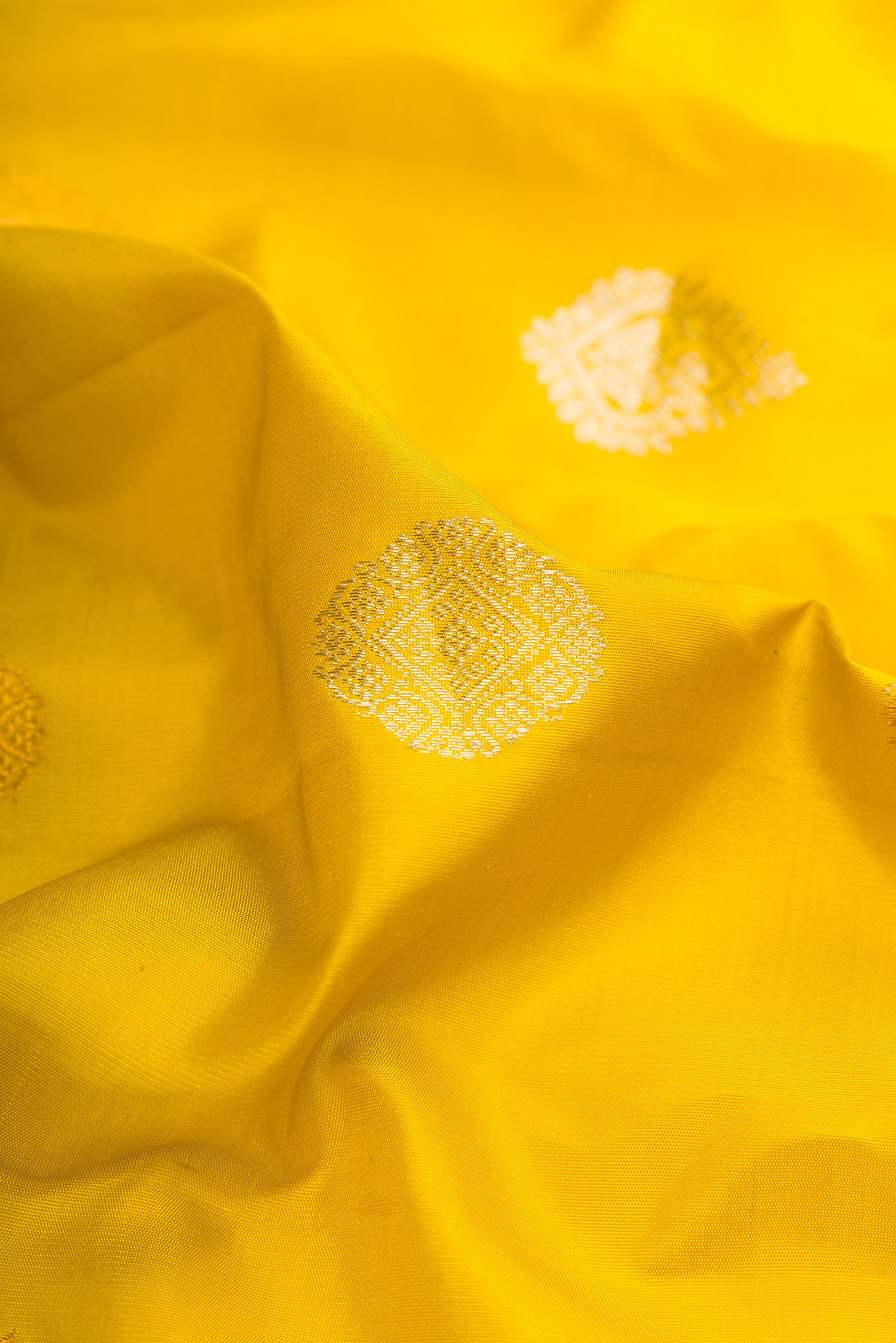 Close up of Mustard Gadwal Silk Saree with Zari Butta on the body and Temple Border.  displaying folds