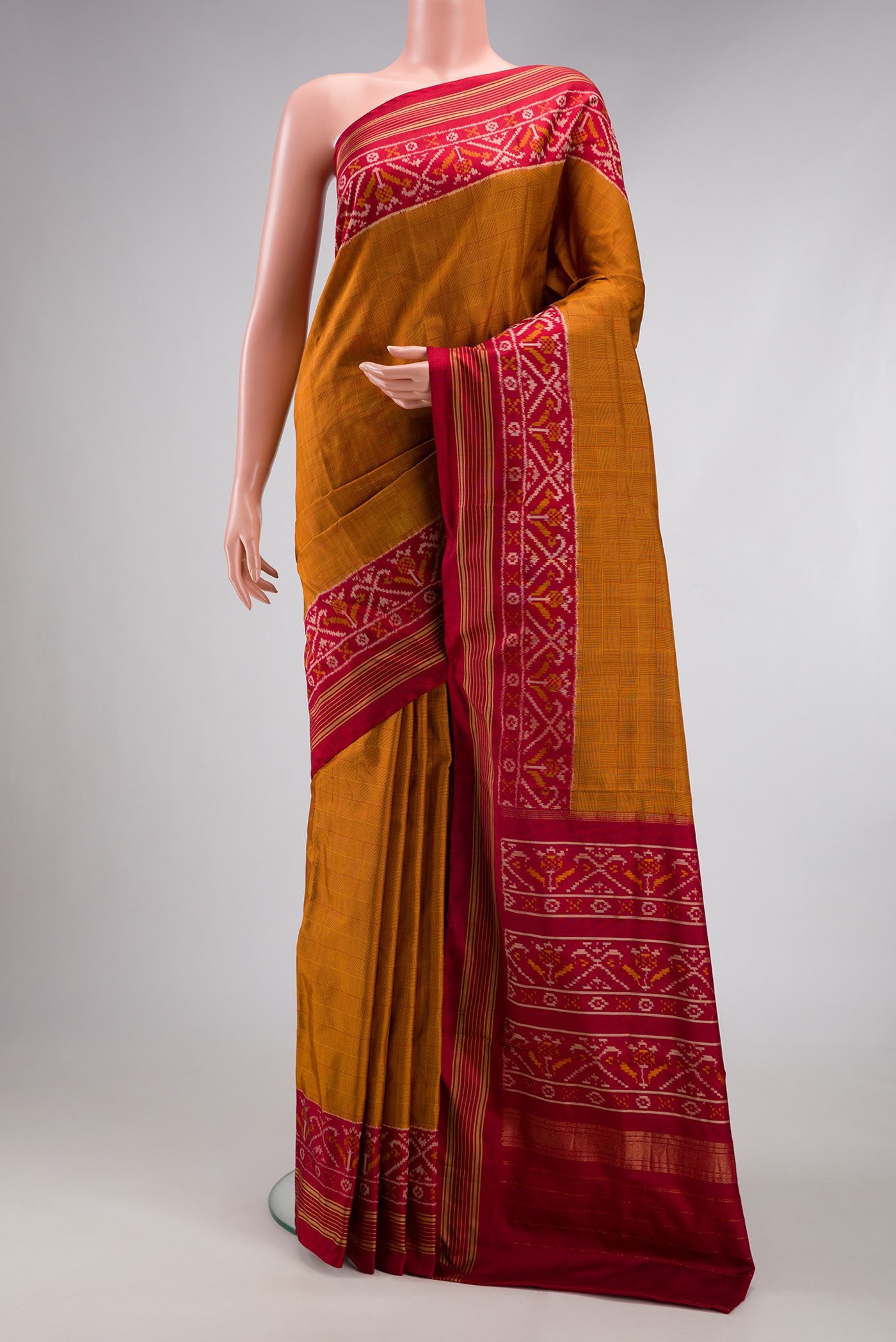 Mustard Double Ikat Saree with Checked design on the body and Ikat Border.  displayed on a mannequin