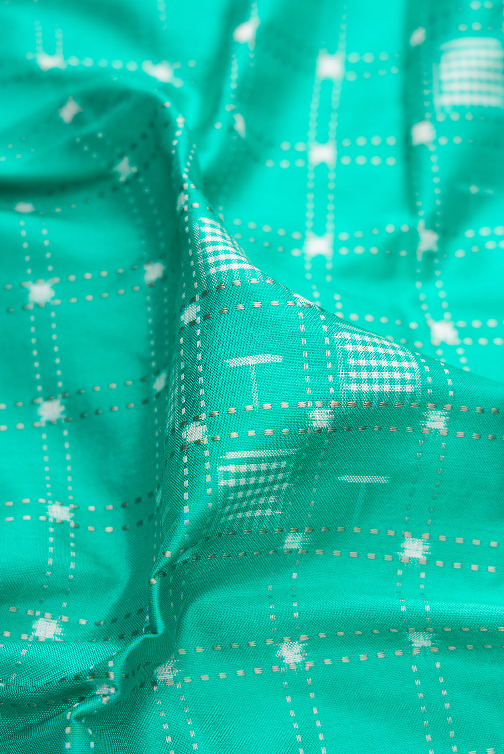 Close up of Sea Green Double Ikat Saree with Pure Ikat on the body and Zari Border.  displaying folds