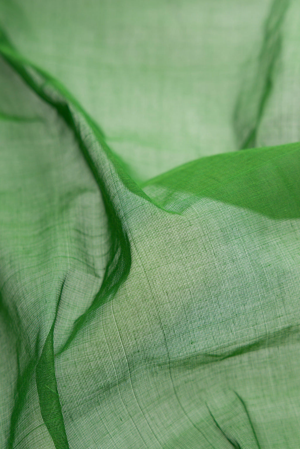 Close up of Green Uppada Cotton Saree with Plain Body and Zari Border.  displaying folds