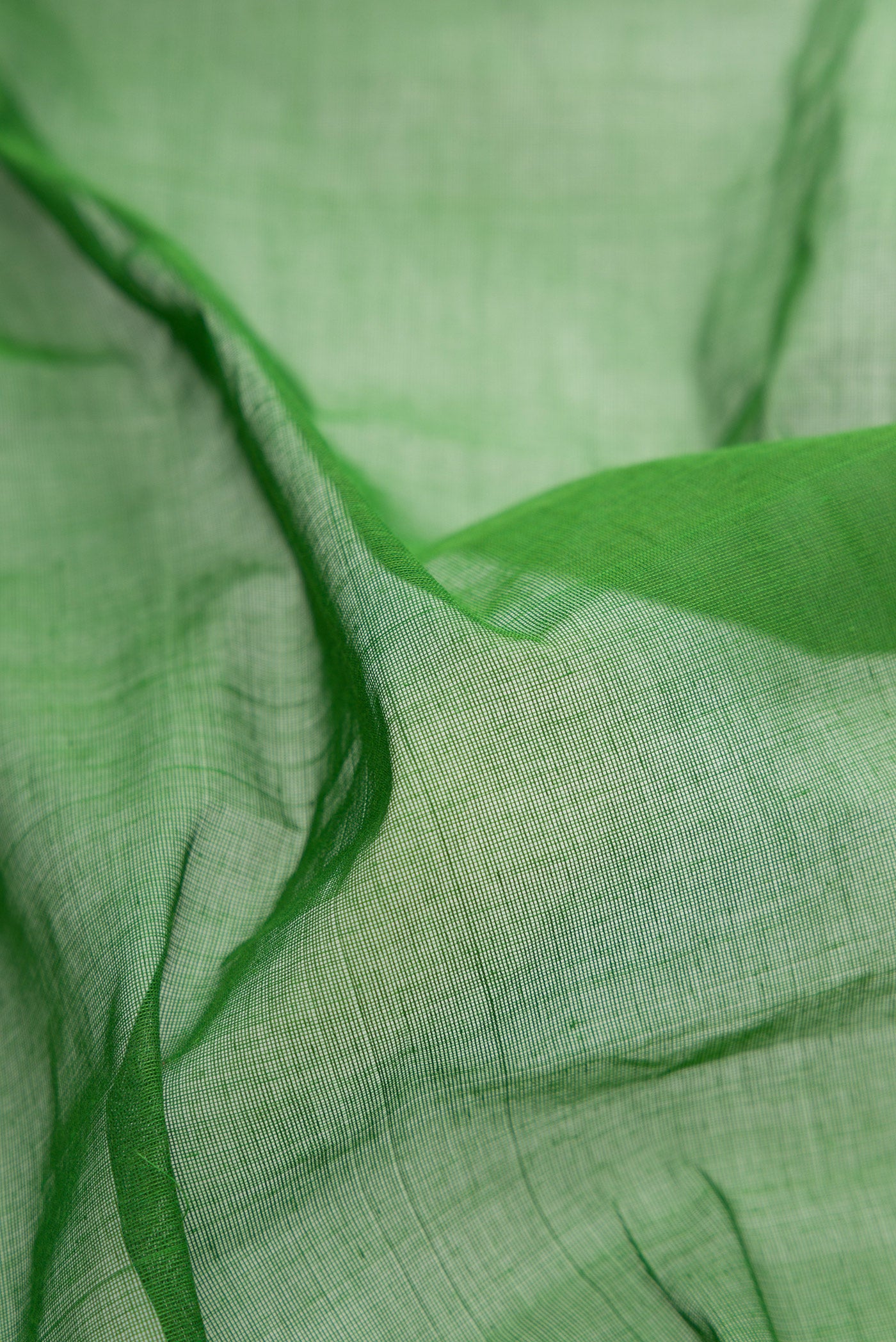 Close up of Green Uppada Cotton Saree with Plain Body and Zari Border.  displaying folds