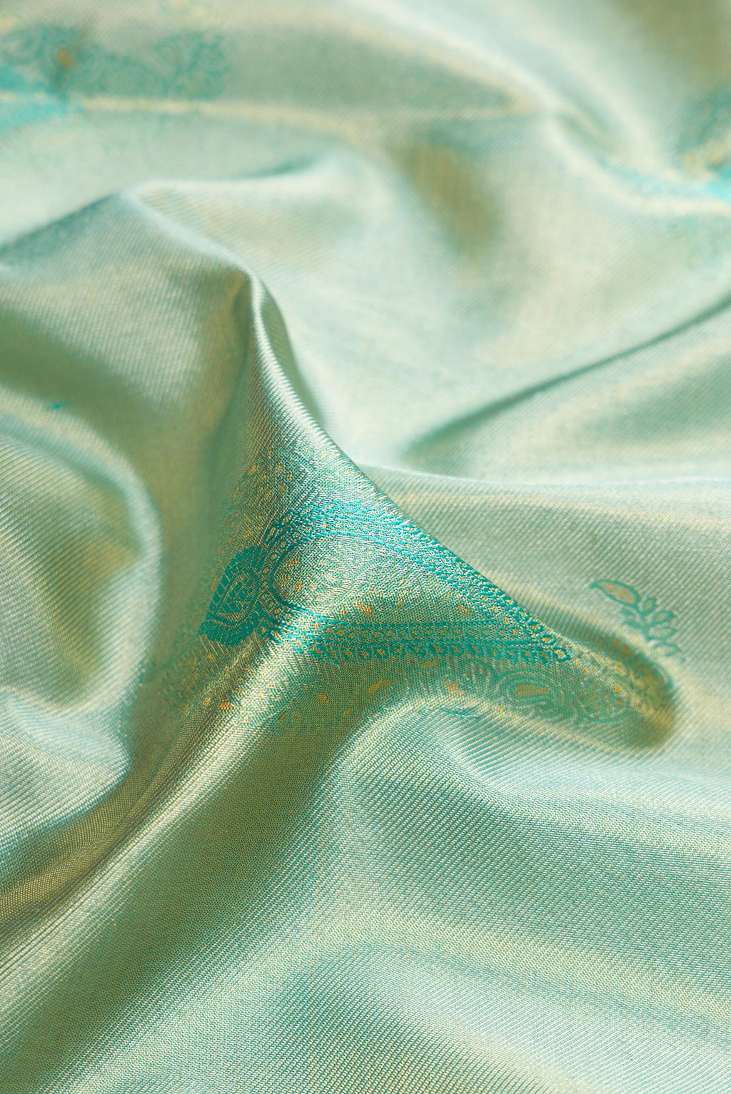 Close up of Sea Green Dual Tone Kanchipuram Tissue Silk Saree with Zari Brocade on the body and Zari Border.  displaying folds