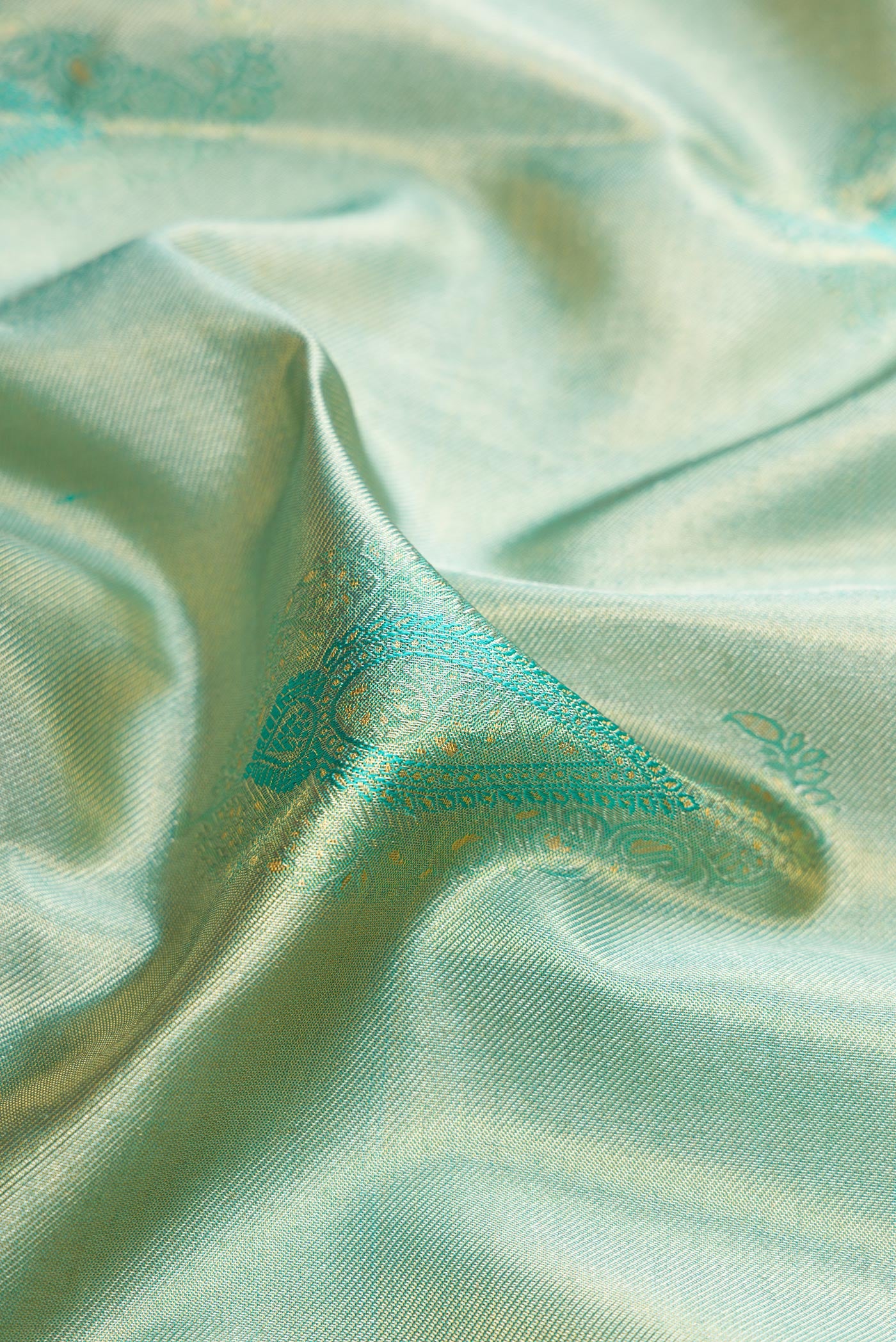 Close up of Sea Green Dual Tone Kanchipuram Tissue Silk Saree with Zari Brocade on the body and Zari Border.  displaying folds