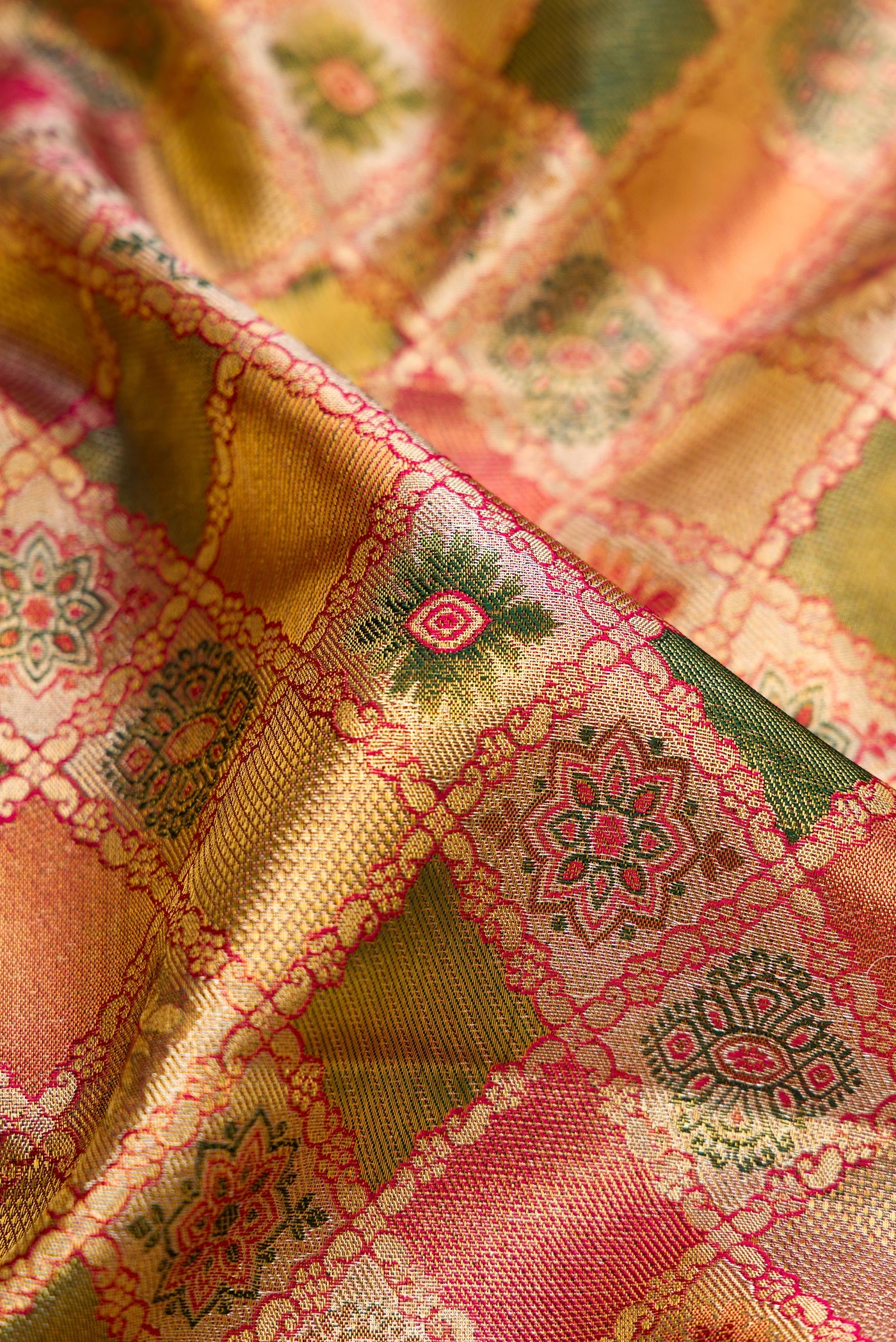 Close up of Green and Pink Color Kanjivaram Tissue Silk Saree with Zari Brocade on the body and Fancy Border.  displaying folds