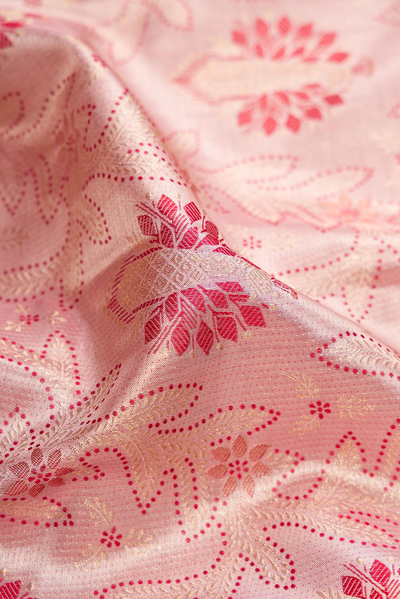 Close up of Rose Gold Dual Tone Kanjivaram Tissue Silk Saree with Zari Brocade on the body and Fancy Border.  displaying folds