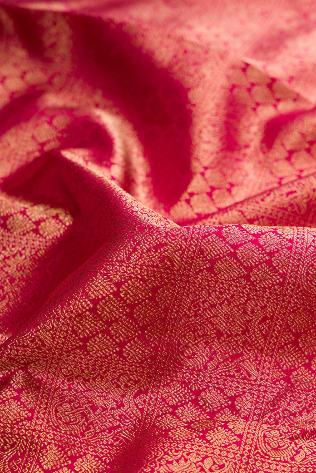 Close up of Dark Pink Dual Tone Kanjivaram Silk Saree with Zari Brocade on the body and Fancy Border.  displaying folds