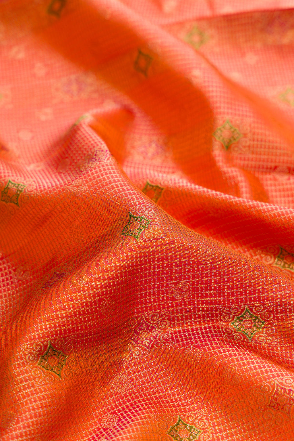Close up of Pure Silk Orange Kanjivaram Saree with Zari Brocade on the body and Fancy Border.  displaying folds