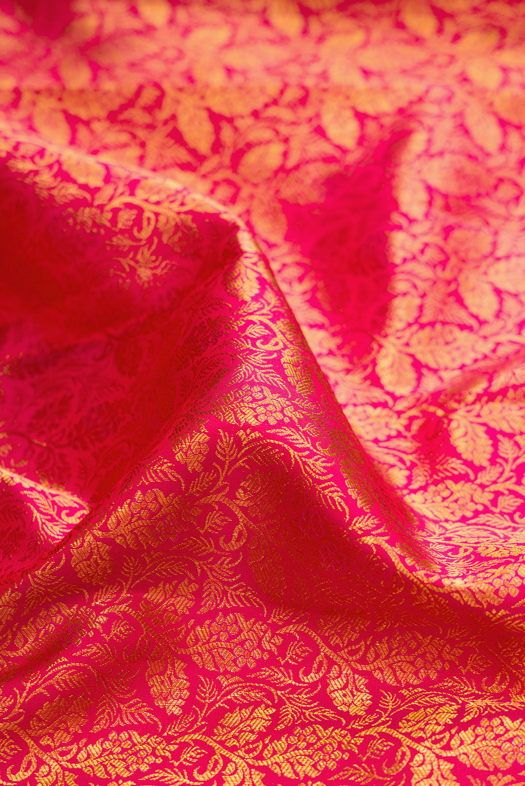 Close up of Dark Pink Kanjivaram Silk Saree with Zari Brocade on the body and Zari Border.  displaying folds