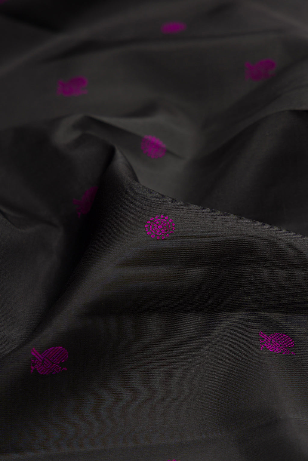 Close up of Black Kanchipuram Silk Saree with Thread Butta on the body and Thread Border.  displaying folds