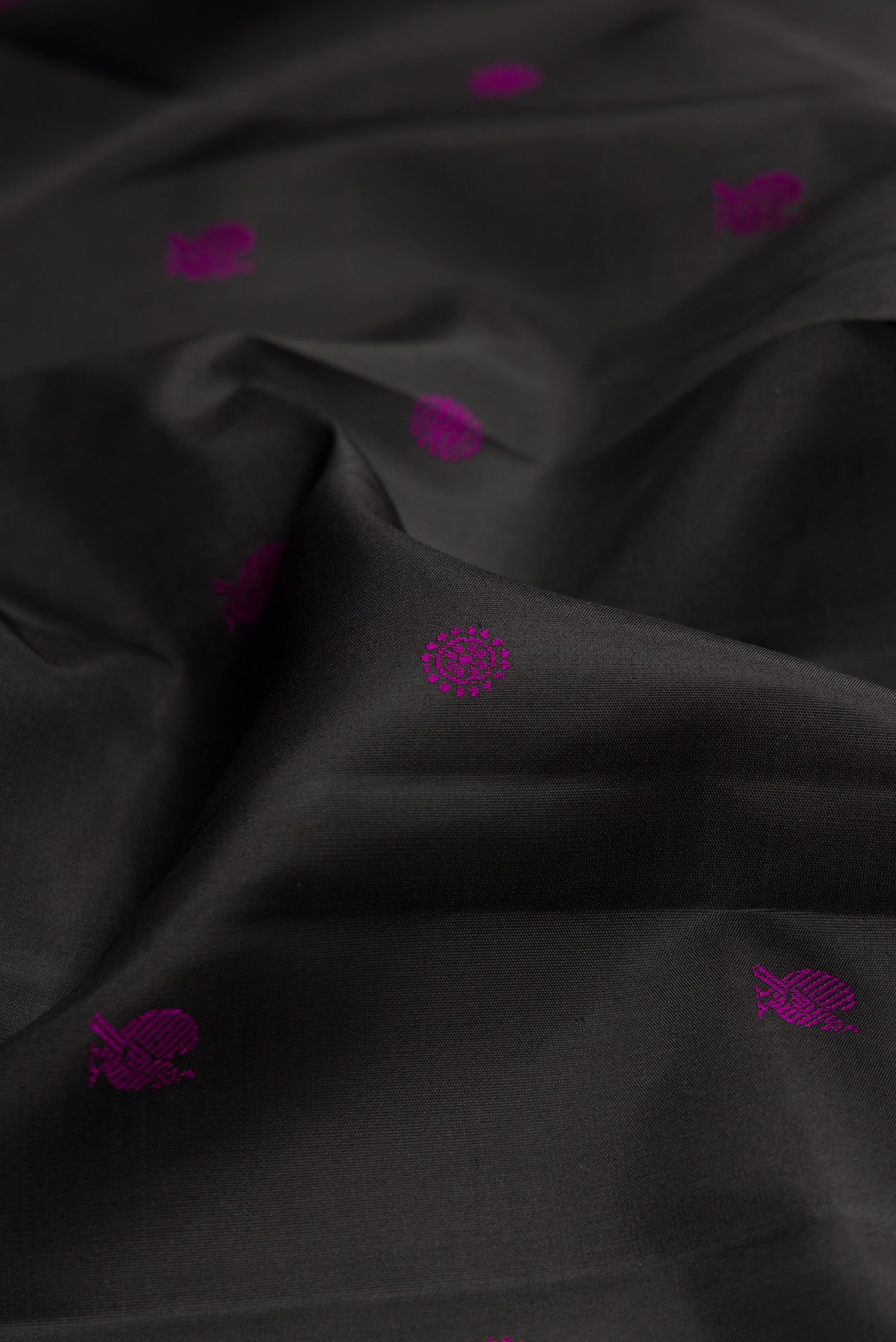 Close up of Black Kanchipuram Silk Saree with Thread Butta on the body and Thread Border.  displaying folds