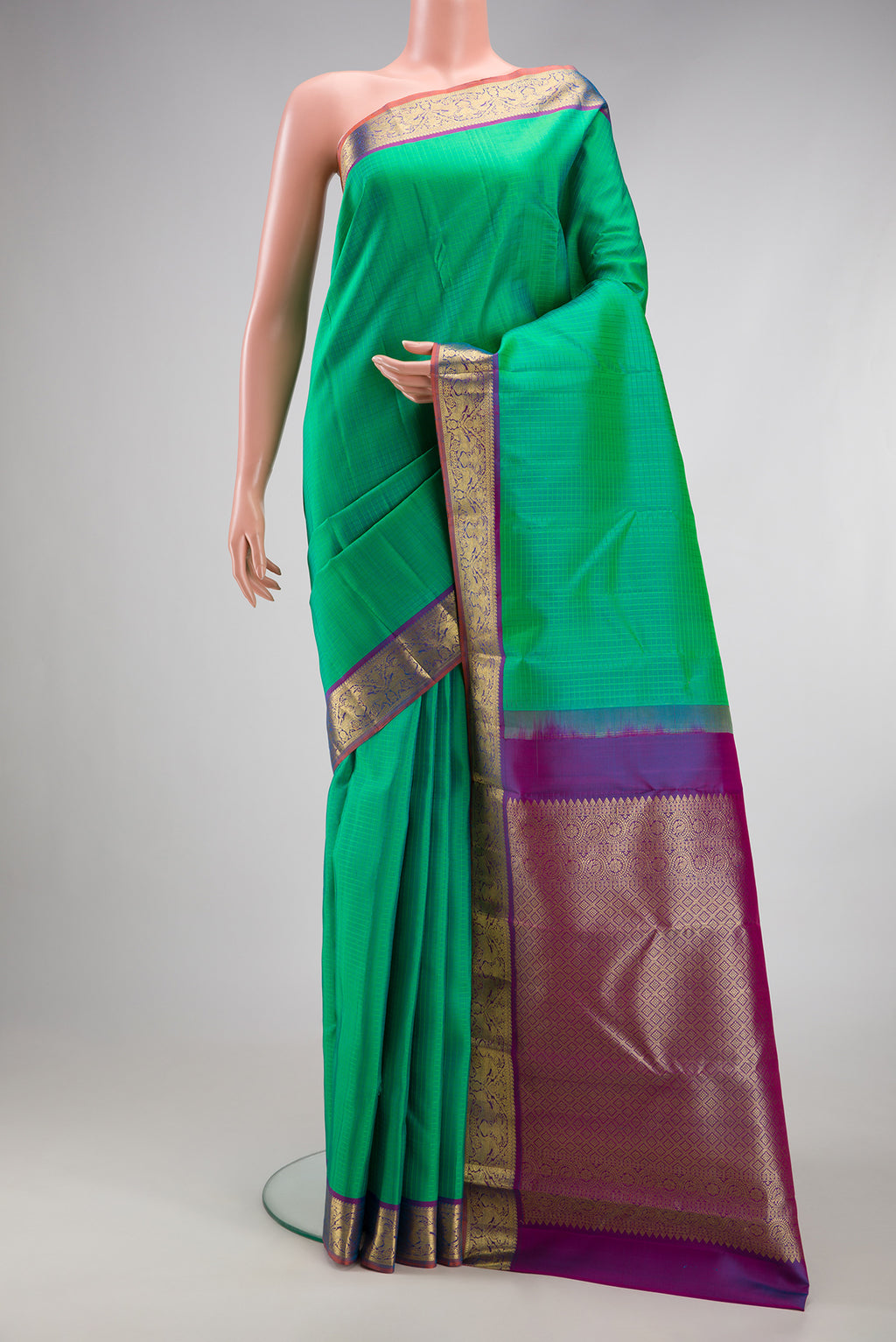 Green Kanchipuram Silk Saree with Checked design on the body and Zari Border.  displayed on a mannequin