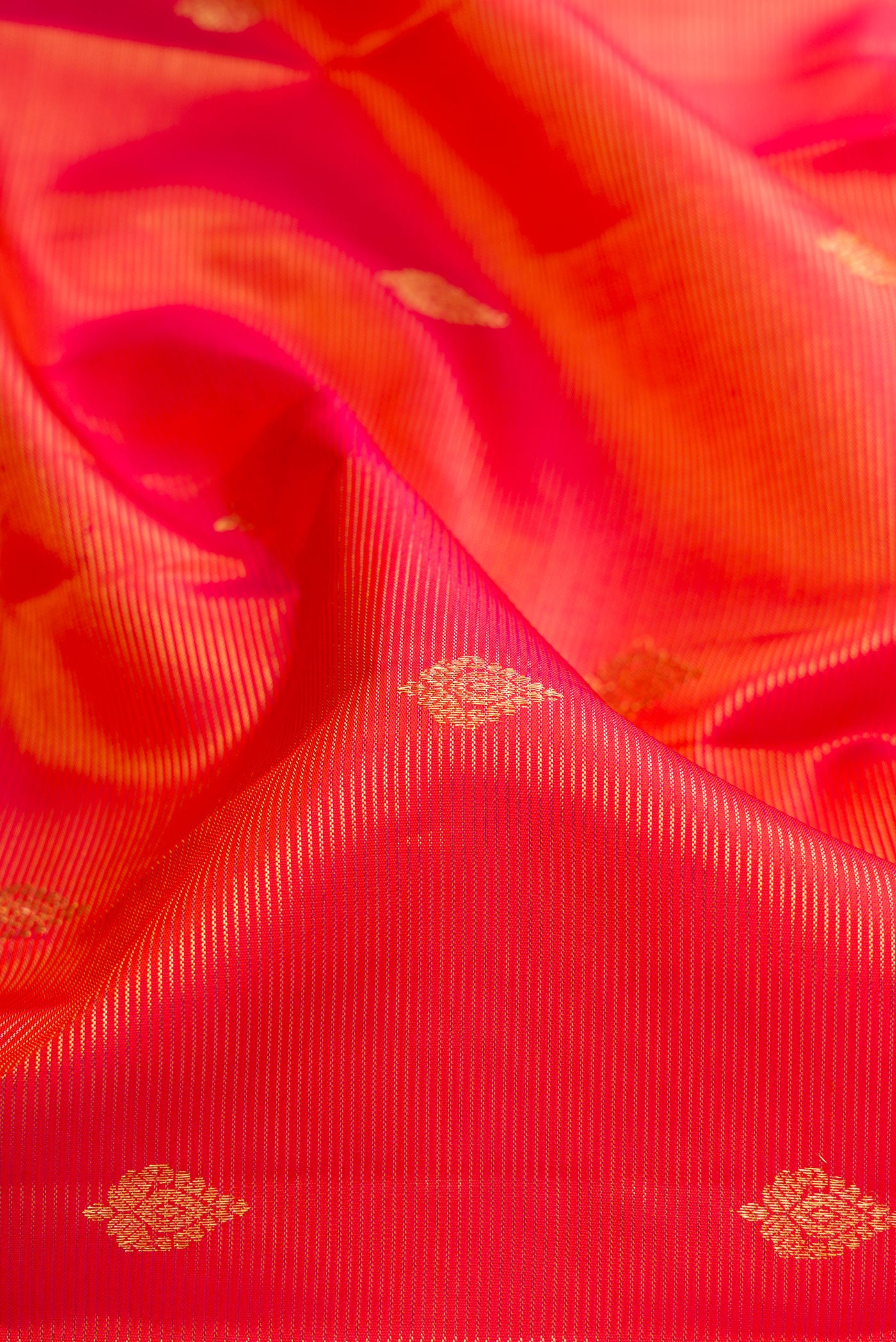 Close up of Orange Kanchipuram Silk Saree with Stripes on the body and Fancy Border.  displaying folds