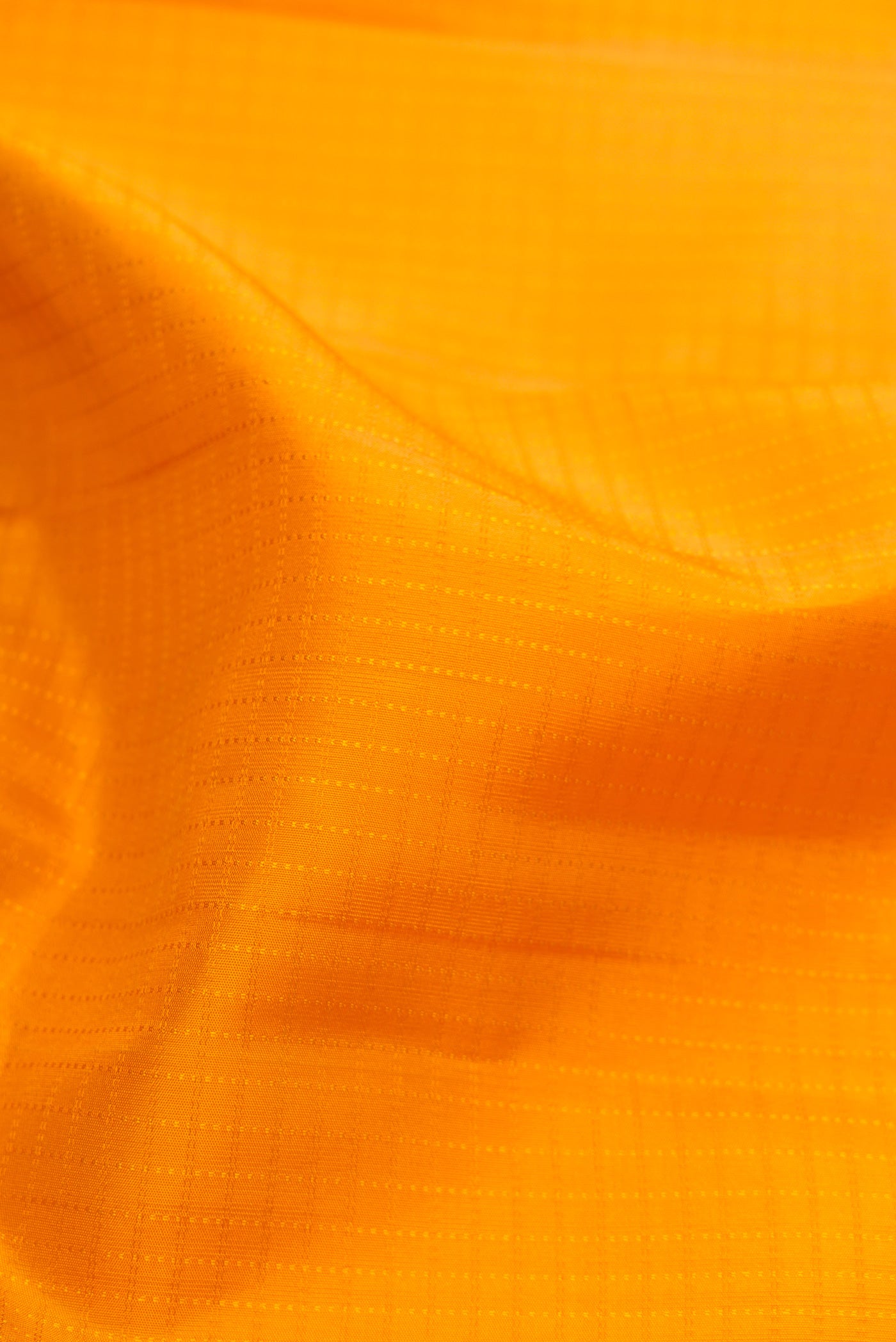 Close up of Yellow Kanchipuram Silk Saree with Checked design on the body and Zari Border.  displaying folds