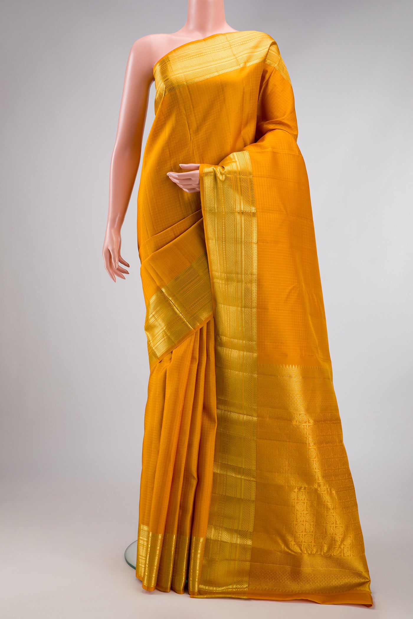 Yellow Kanchipuram Silk Saree with Checked design on the body and Zari Border.  displayed on a mannequin