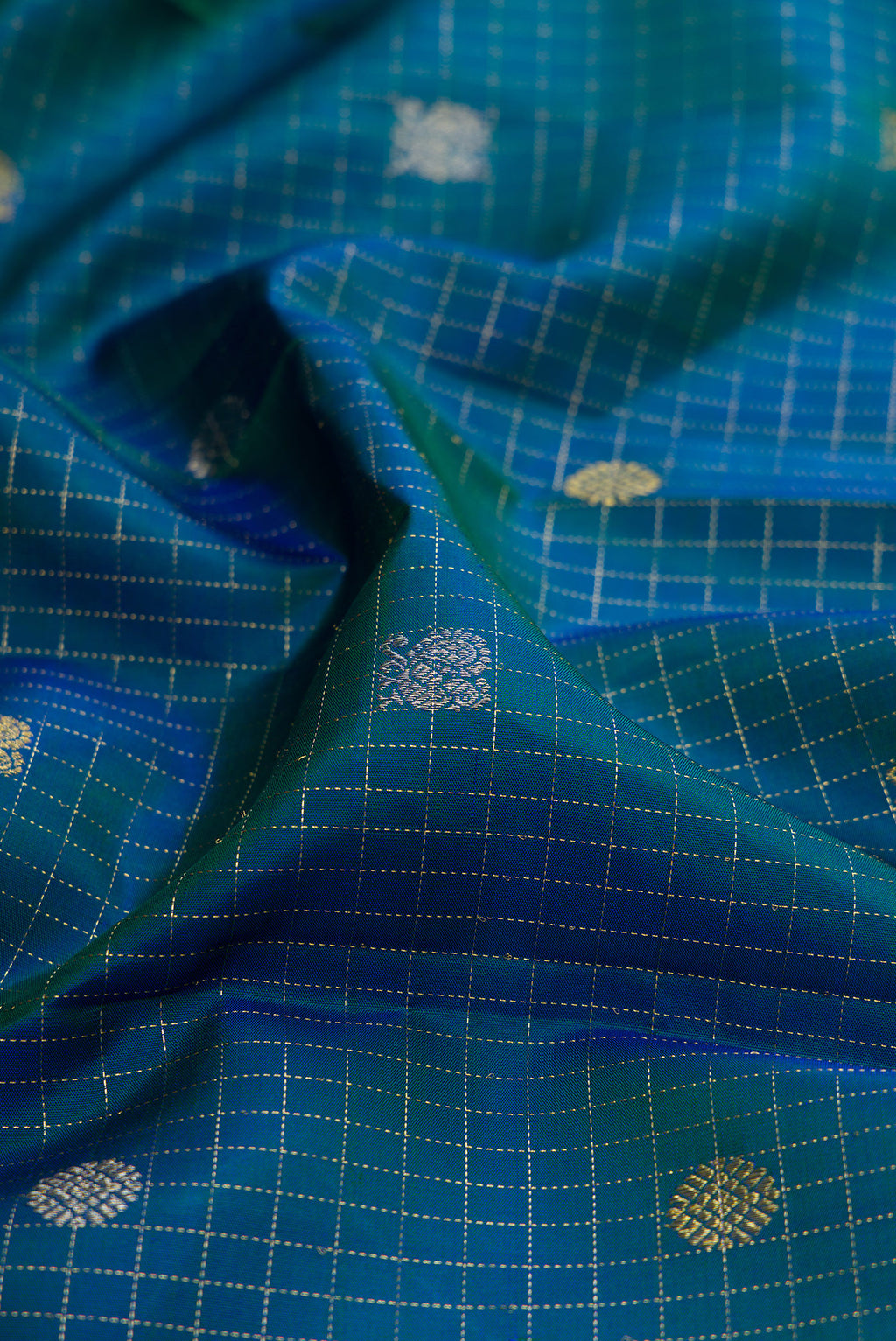 Close up of Peacock Blue Dual Tone Kanjivaram Silk Saree with Checked design on the body and Fancy Border.  displaying folds
