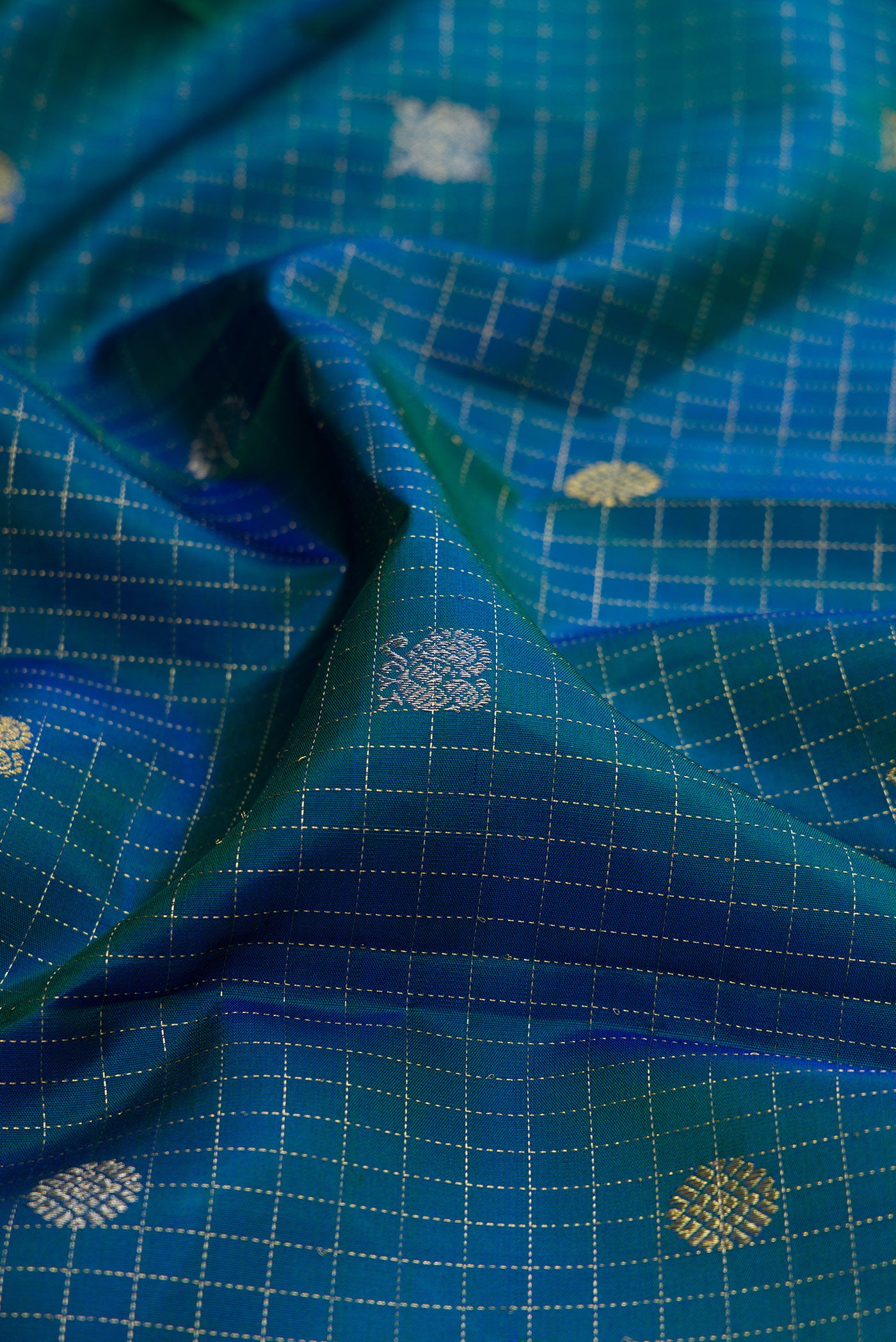 Close up of Peacock Blue Dual Tone Kanjivaram Silk Saree with Checked design on the body and Fancy Border.  displaying folds