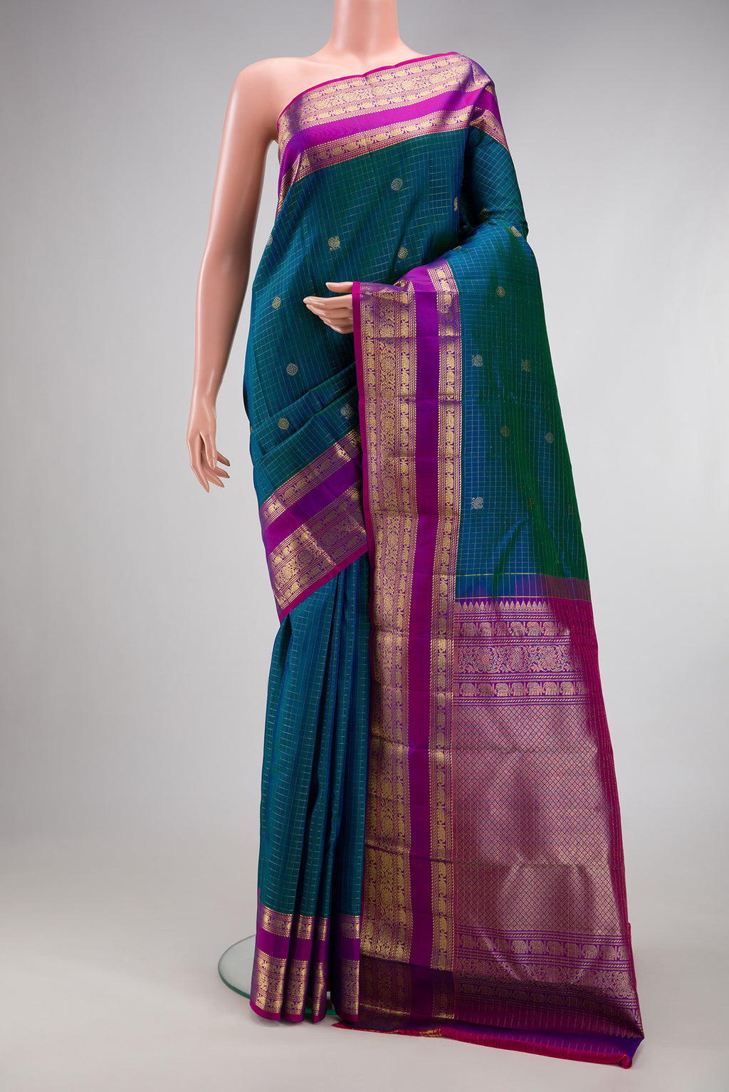 Peacock Blue Dual Tone Kanjivaram Silk Saree with Checked design on the body and Fancy Border.  displayed on a mannequin