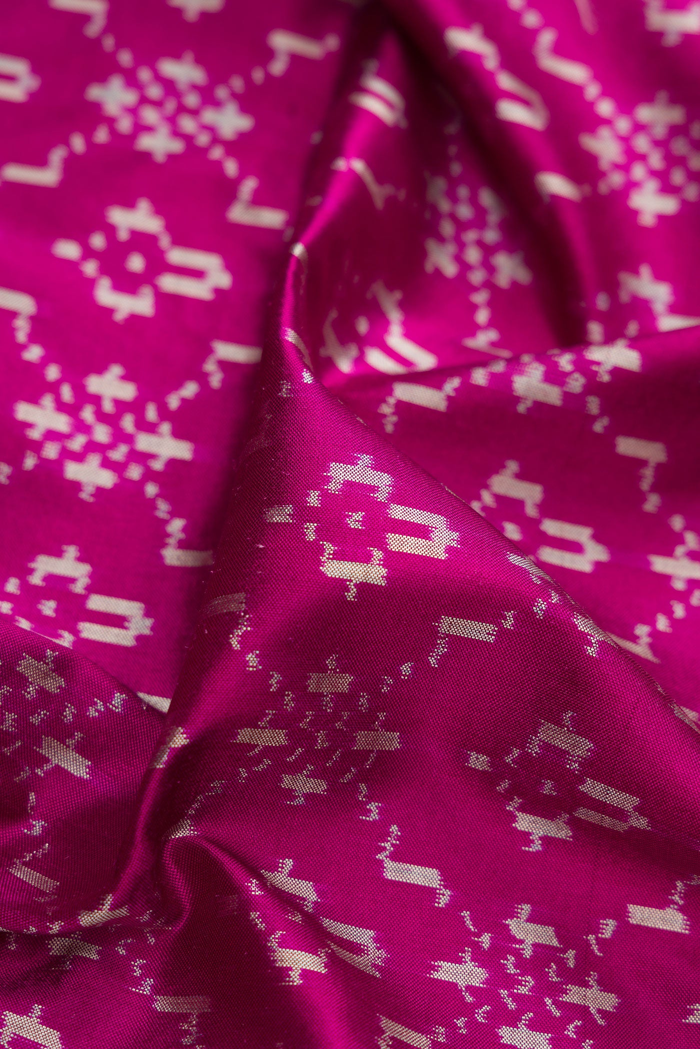 Close up of Magenta Double Ikat Saree with Pure Ikat on the body and Zari Border.  displaying folds