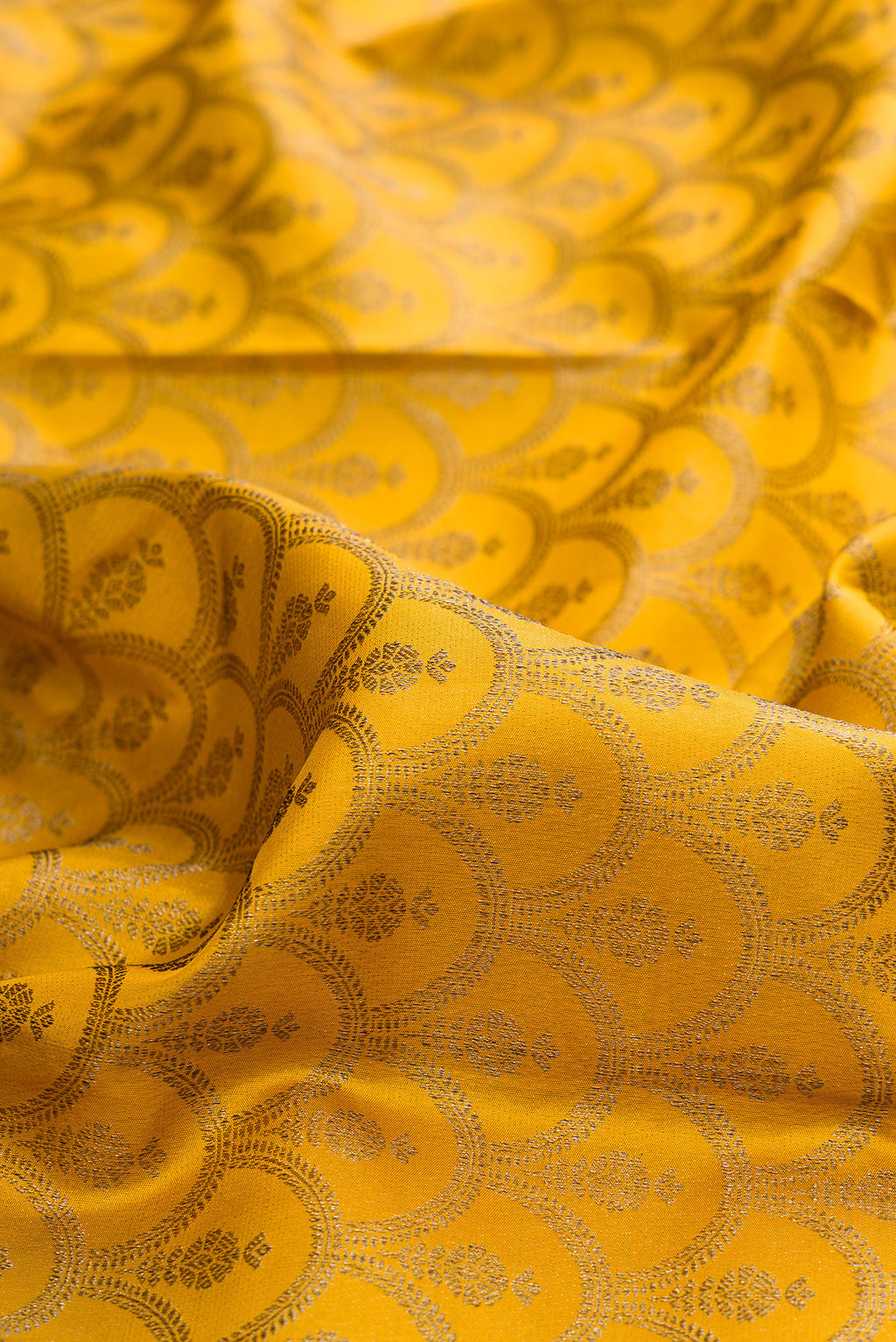 Close up of Pure Silk Mustard Kanjivaram Saree with Zari Brocade on the body and Zari Border.  displaying folds