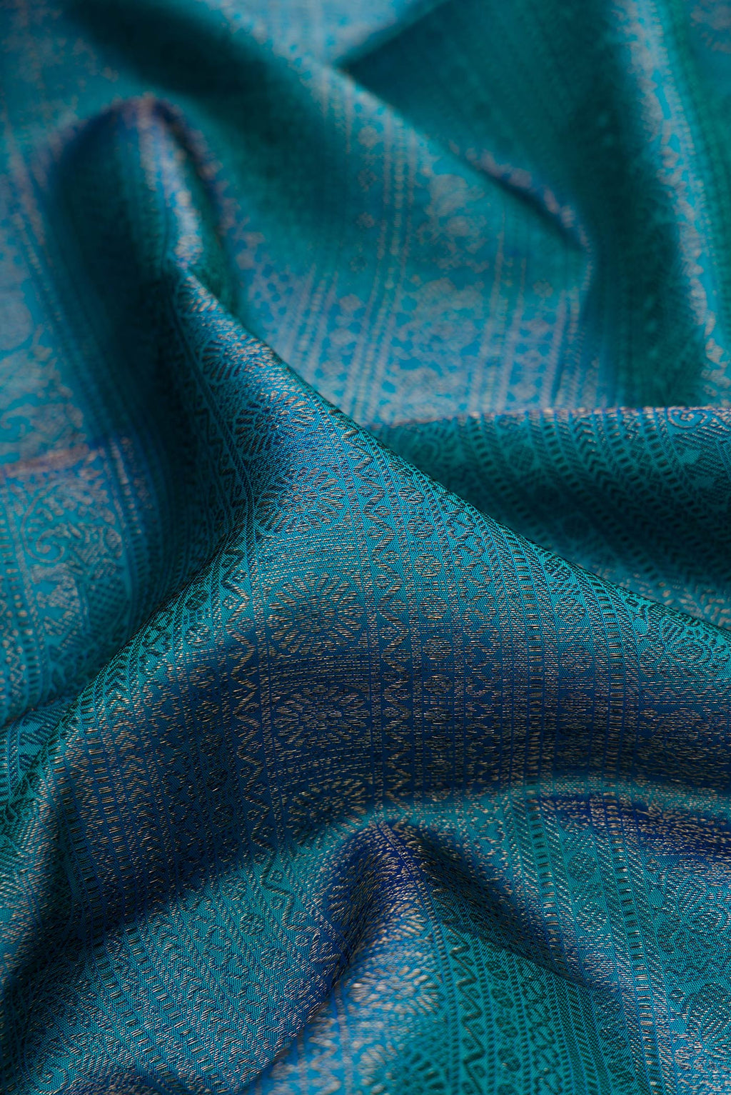 Close up of Pure Silk Peacock Blue Kanjivaram Saree with Zari Brocade on the body and Zari Border.  displaying folds