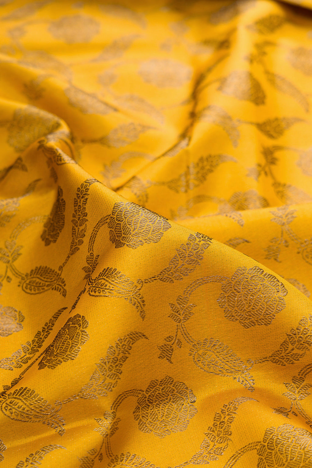 Close up of Pure Silk Mustard Kanjivaram Saree with Zari Brocade on the body and Fancy Border.  displaying folds