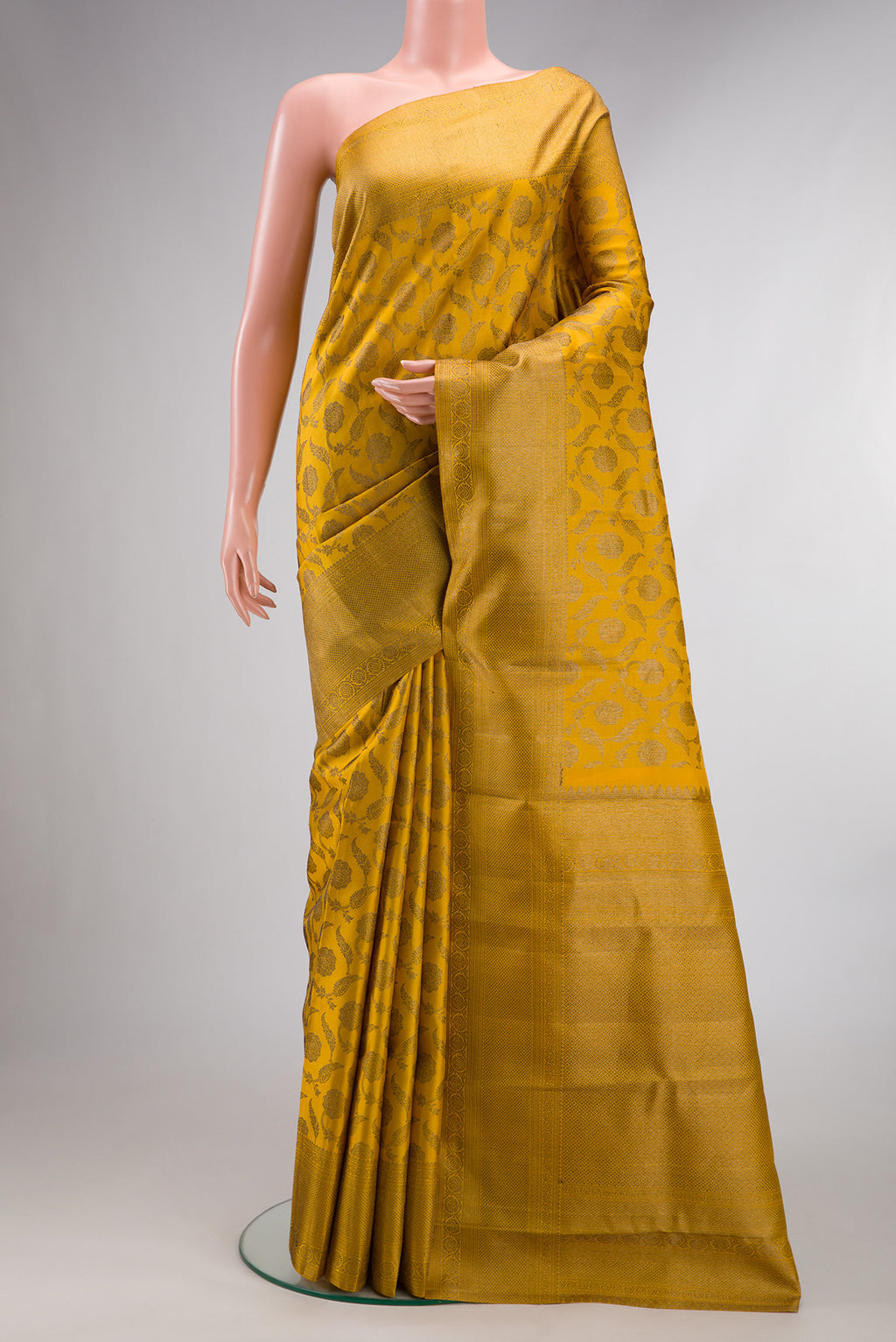 Pure Silk Mustard Kanjivaram Saree with Zari Brocade on the body and Fancy Border.  displayed on a mannequin