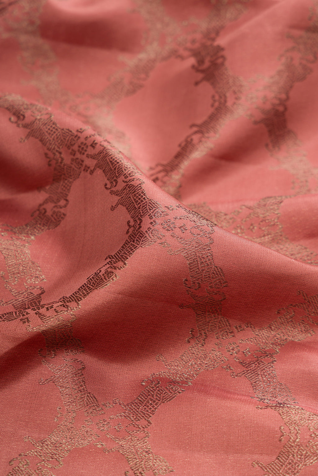 Close up of Coral Kanjivaram Silk Saree with Jacquard design on the body and Fancy Border.  displaying folds