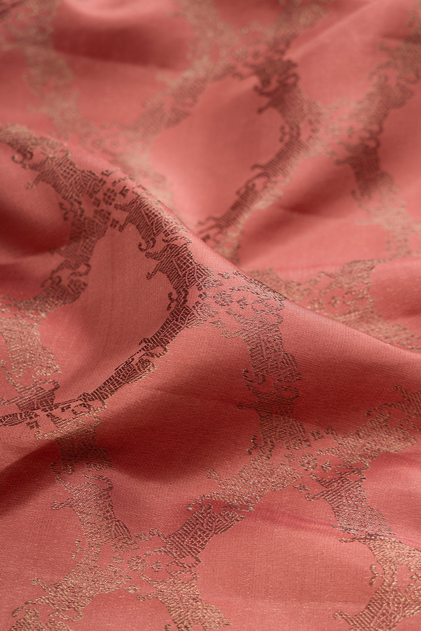 Close up of Coral Kanjivaram Silk Saree with Jacquard design on the body and Fancy Border.  displaying folds