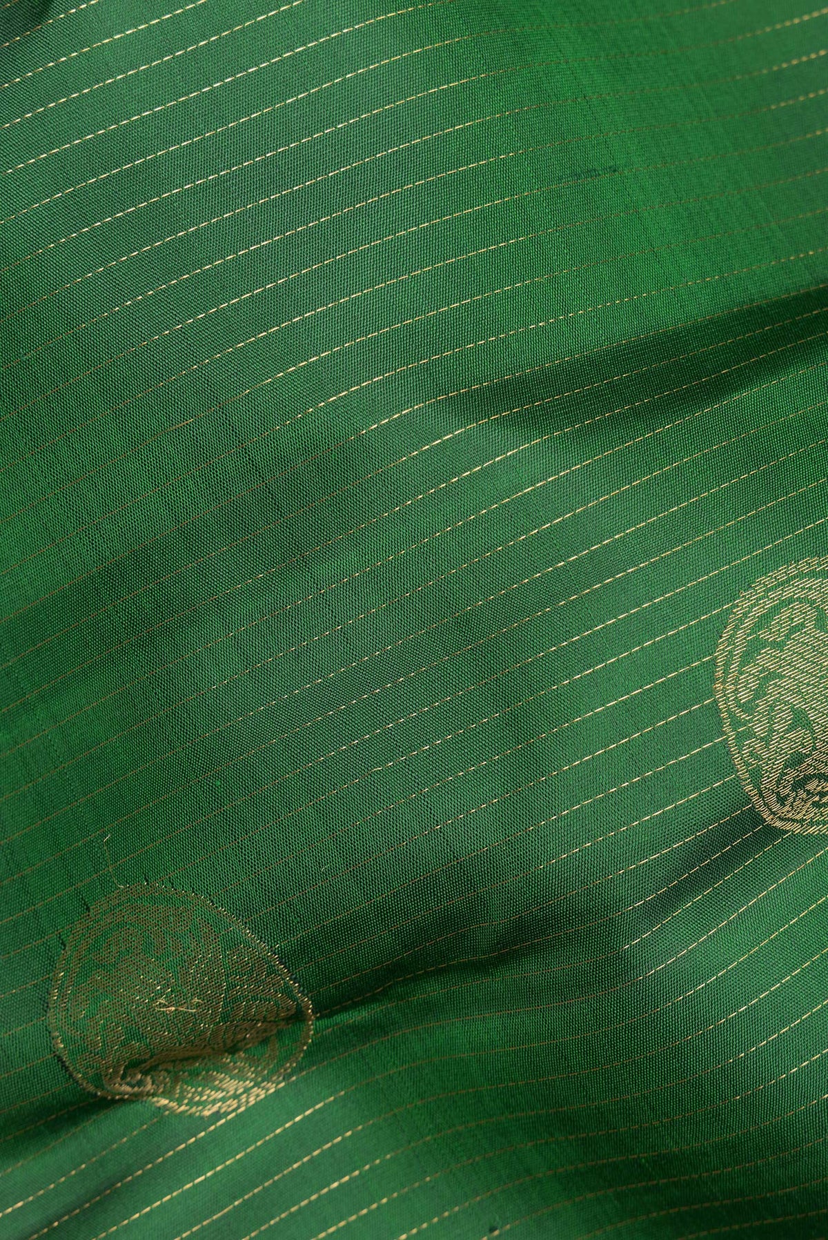 Close up of Pure Silk Green Kanjivaram Saree with Stripes on the body and Zari Border.  displaying folds