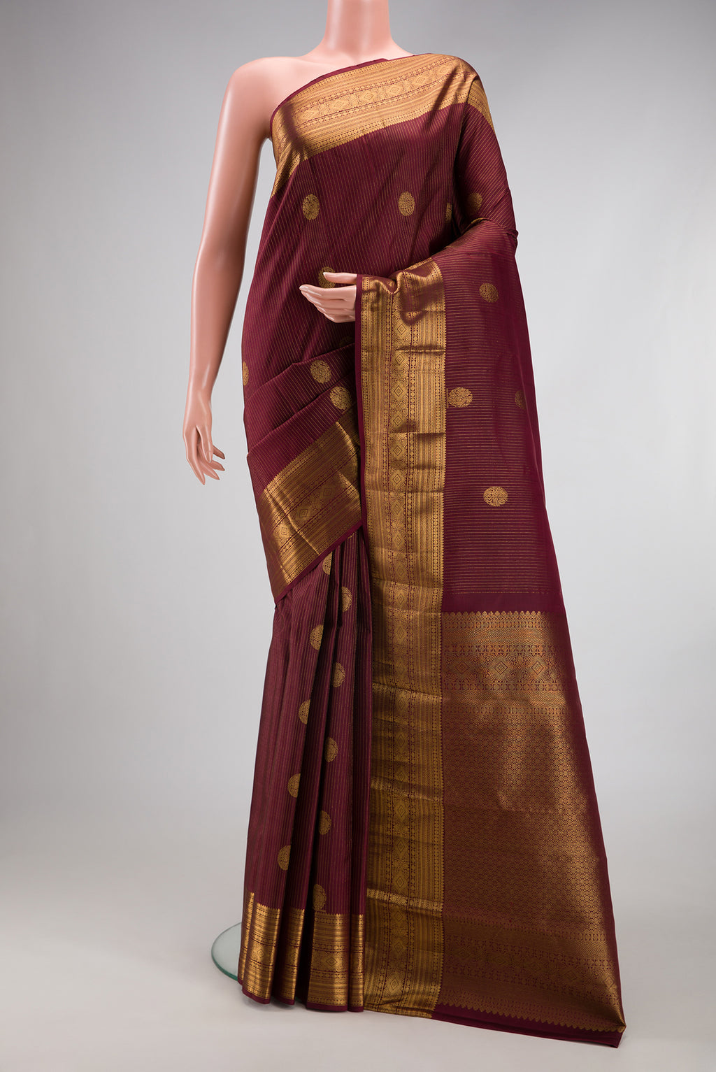 Coffee Brown Kanjivaram Silk Saree with Stripes on the body and Zari Border.  displayed on a mannequin