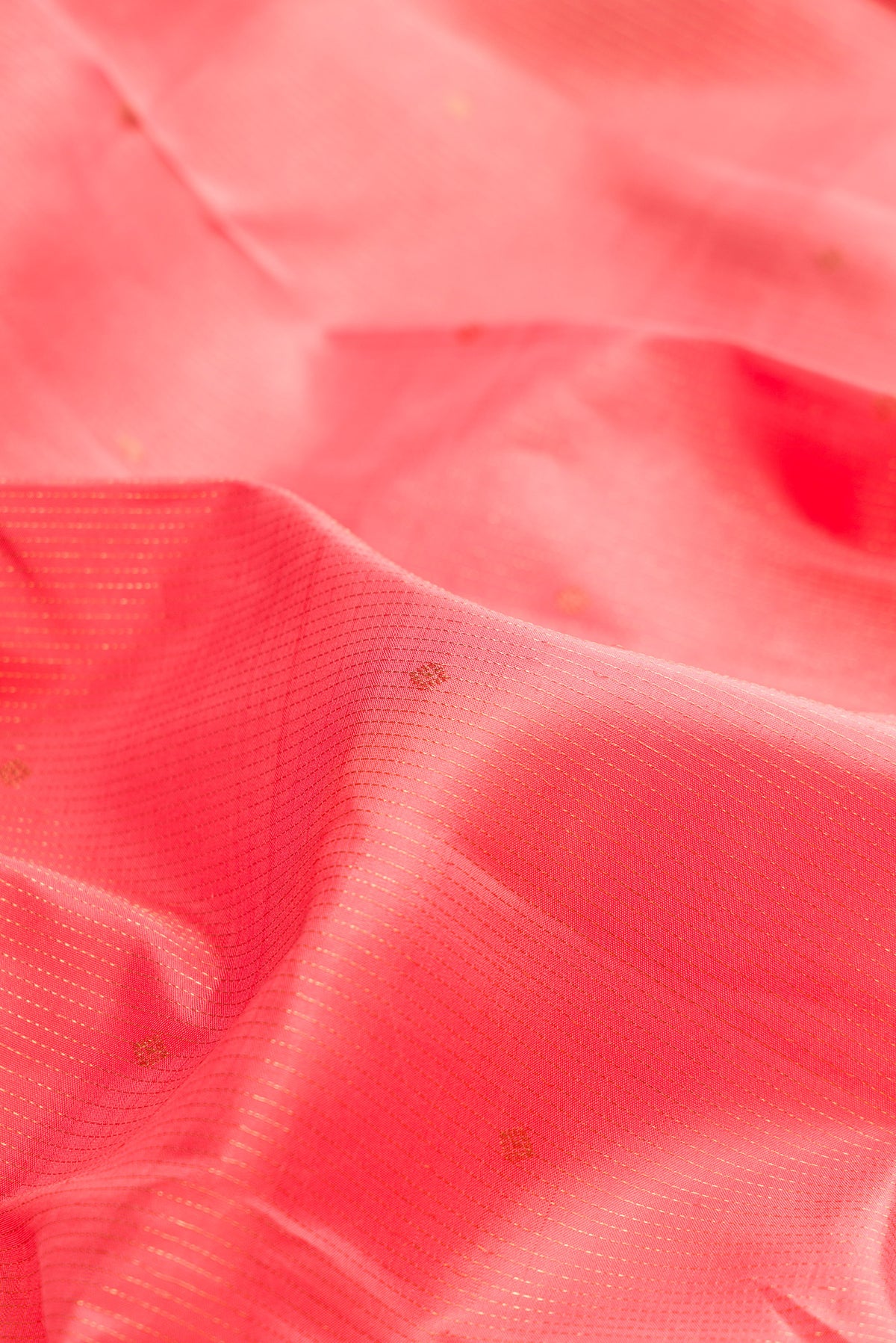 Close up of Pure Silk Coral Kanjivaram Saree with Stripes on the body and Zari Border.  displaying folds