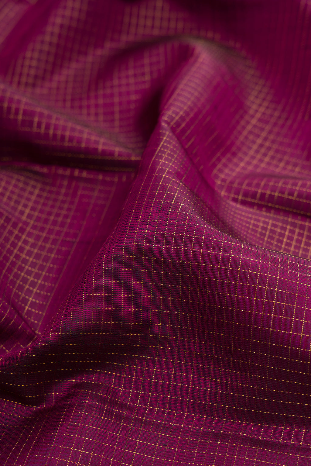 Close up of Magenta Kanjivaram Silk Saree with Checked design on the body and Fancy Border.  displaying folds