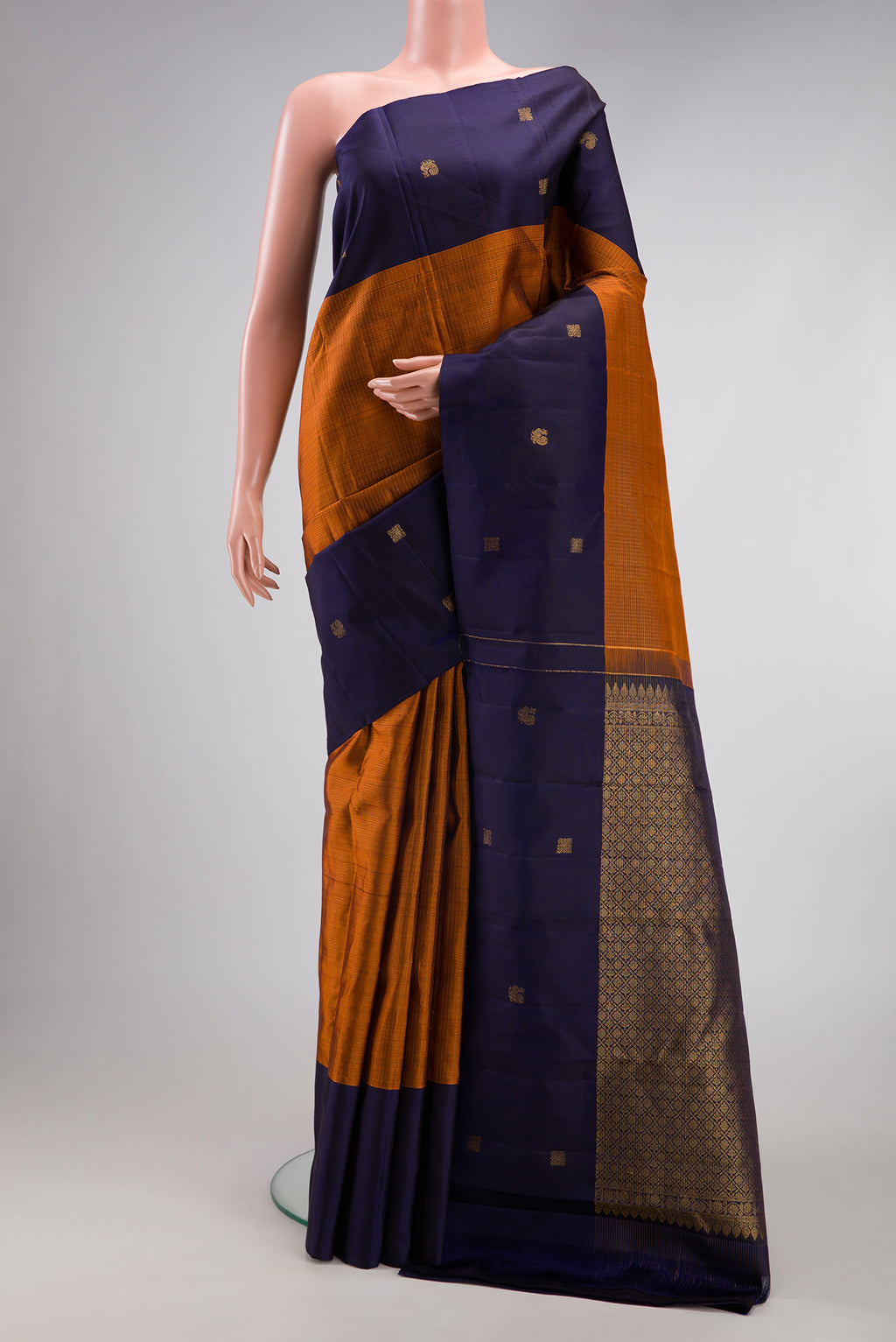 Rust Kanjivaram Silk Saree with Checked design on the body and Fancy Border.  displayed on a mannequin