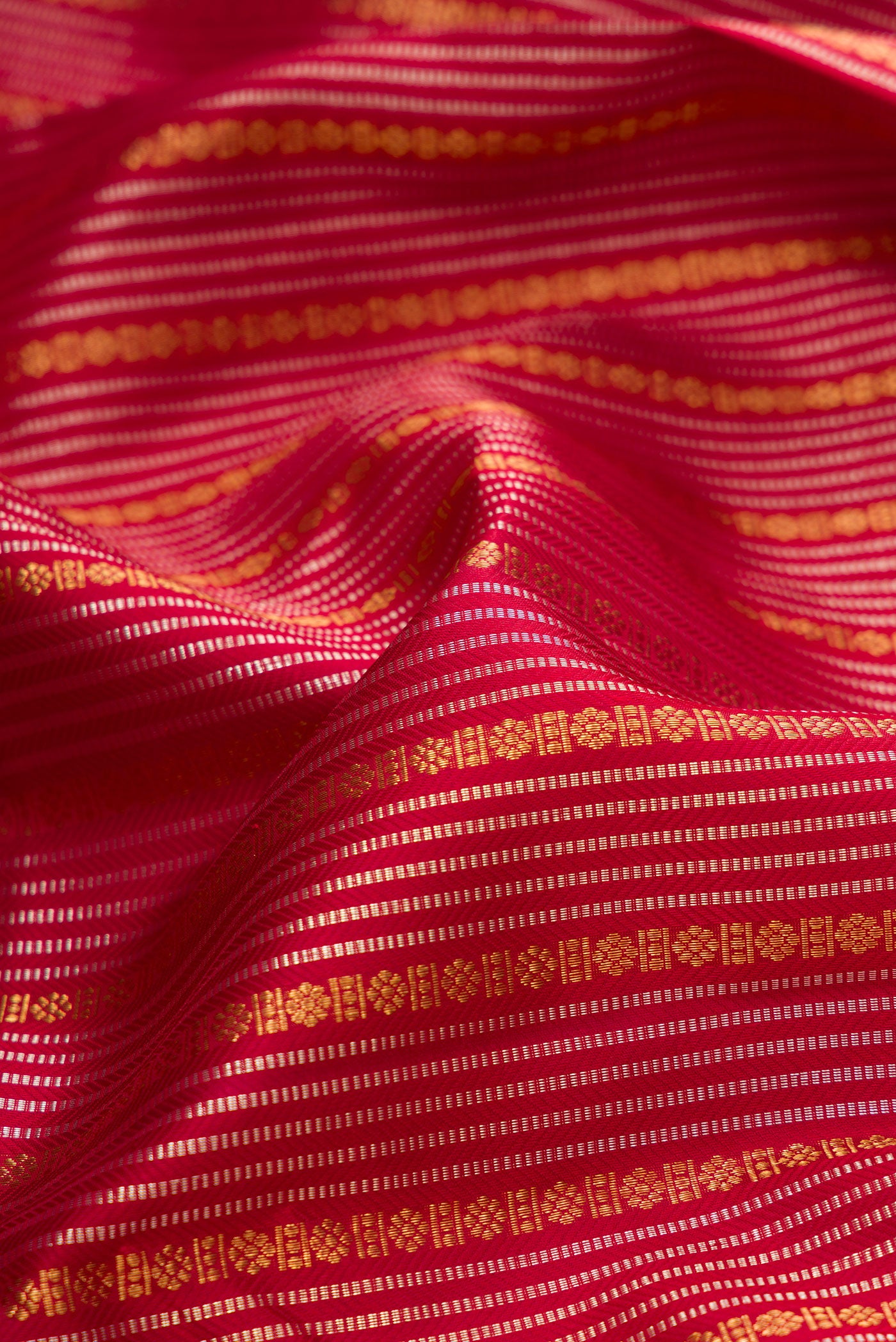 Close up of Maroon Kanjivaram Silk Saree with Stripes on the body and Zari Border.  displaying folds