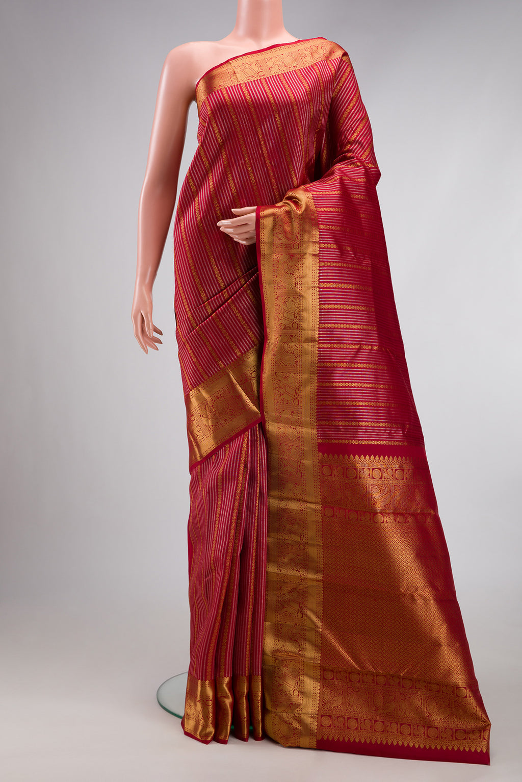 Maroon Kanjivaram Silk Saree with Stripes on the body and Zari Border.  displayed on a mannequin