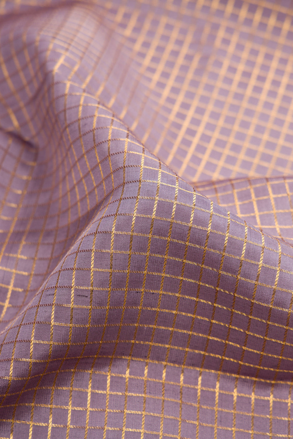 Close up of Lavender Dual Tone Kanjivaram Silk Saree with Checked design on the body and Zari Border.  displaying folds