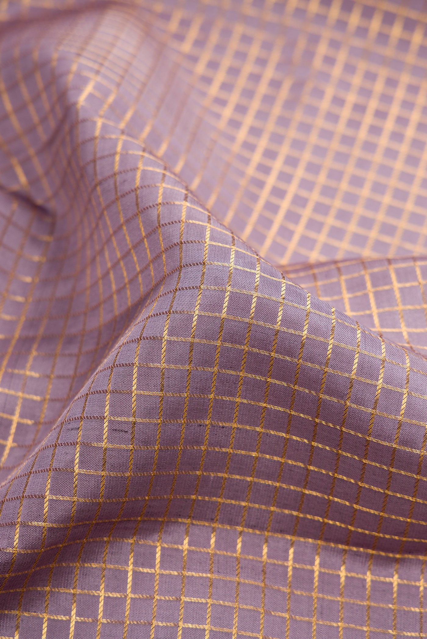 Close up of Lavender Dual Tone Kanjivaram Silk Saree with Checked design on the body and Zari Border.  displaying folds