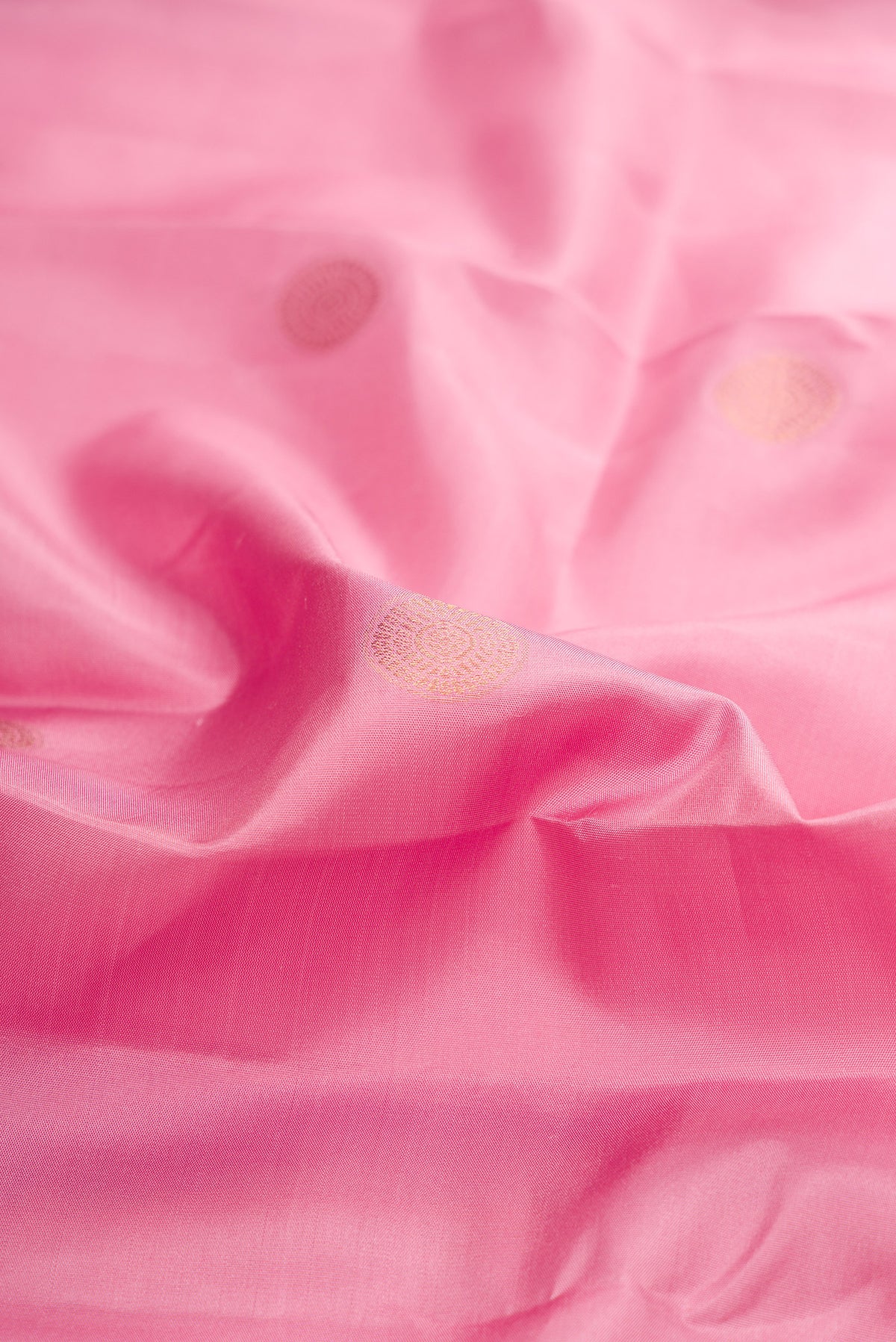 Close up of Pure Silk Rose pink Kanchipuram Saree with Zari Butta on the body and Fancy Border.  displaying folds
