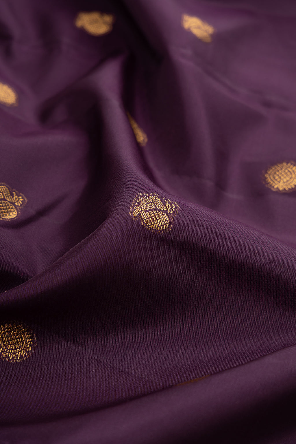 Close up of Burgundy Kanchipuram Silk Saree with Zari Butta on the body and Fancy Border.  displaying folds