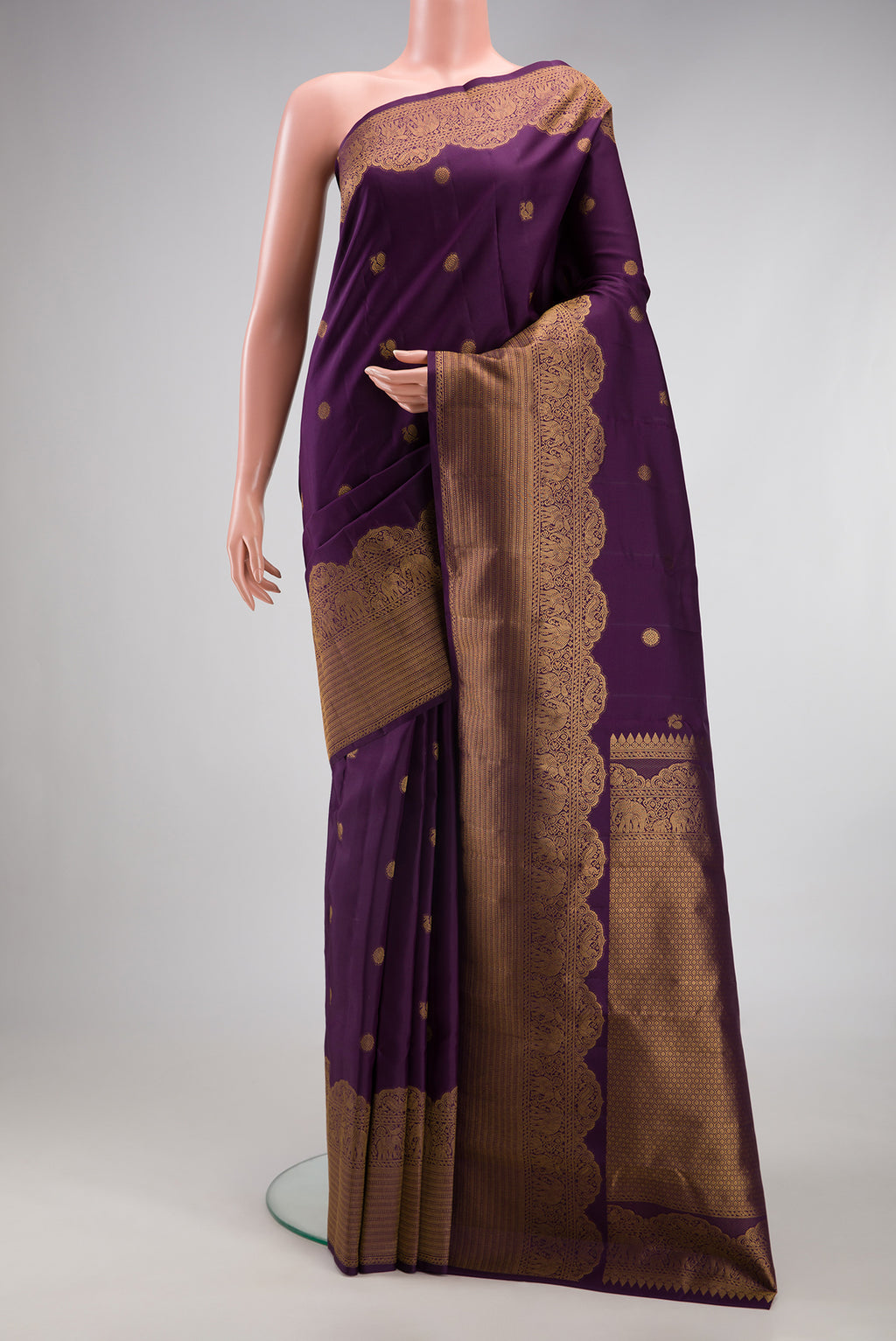 Burgundy Kanchipuram Silk Saree with Zari Butta on the body and Fancy Border.  displayed on a mannequin